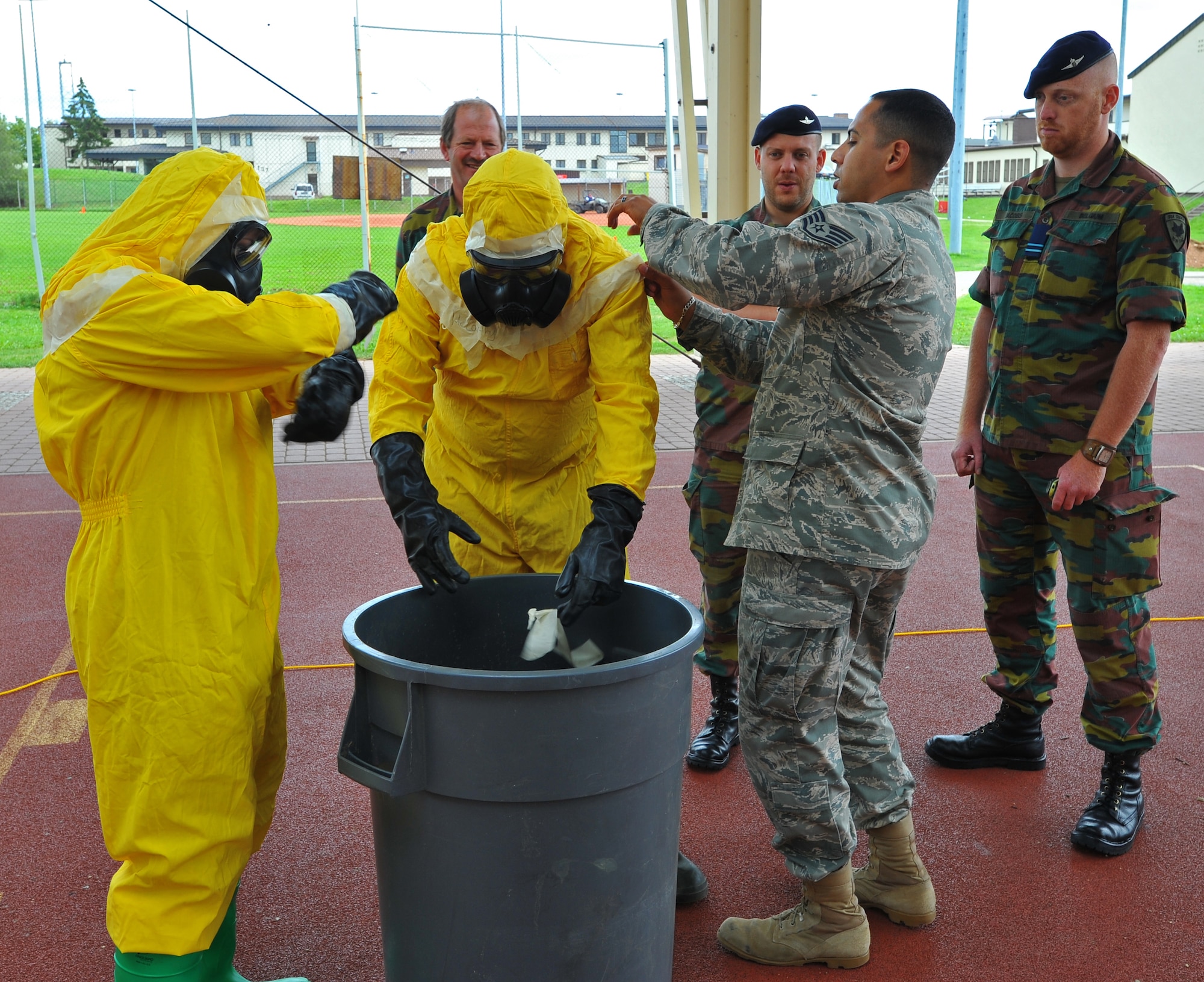 SPANGDAHLEM AIR BASE, Germany – Airmen assigned to the 52nd Civil Engineer Squadron show Belgian air force members how to remove chemical protective gear during a decontamination exercise here June 30. Members of the Belgian air force visited to learn about U.S. Air Force decontamination procedures. (U.S Air Force photo/Airman 1st Class Dillon Davis)