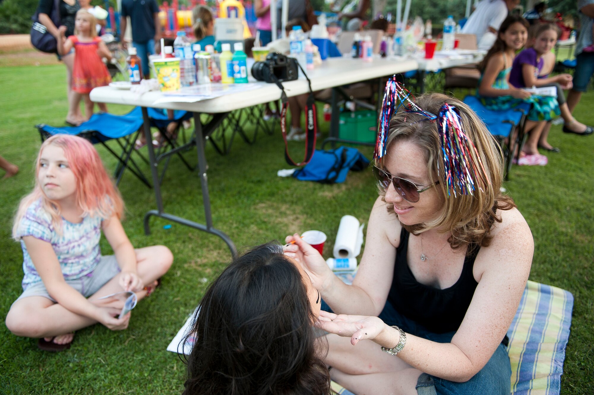 Cassandra Dounglomchan, wife of Staff Sgt. Kitsana Dounglomchan from the 39th Force Support Squadron, paints faces July 2, 2011, at Arkadas Park, Incirlik Air Base, Turkey. Team Incirlik celebrated Independence Day with various activities, food and live entertainment. (U.S. Air Force photo by Tech. Sgt. Michael B. Keller/Released)