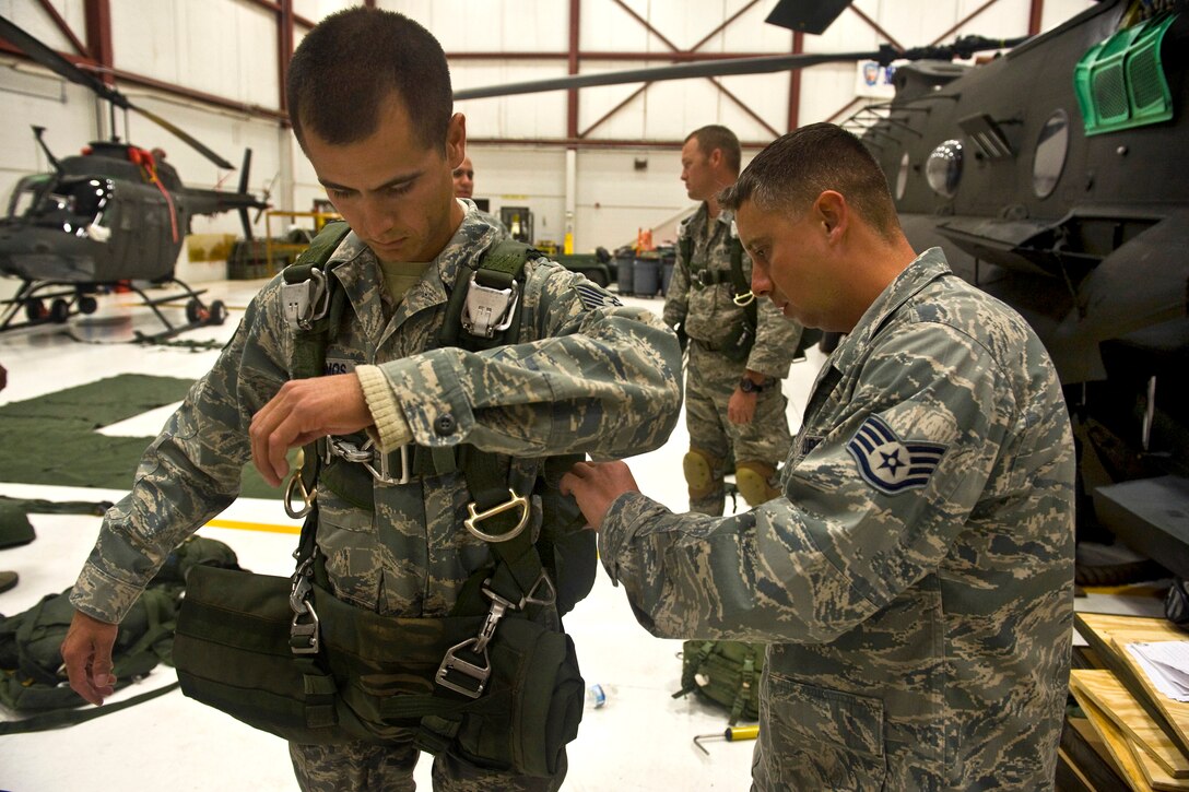 U.S. Air Force Tech. Sgt. Joshua Ramos receives a jump pre-inspection from Staff Sgt. Sean Smyth at the Senator Harry Reid Readiness and Training Center in Stead, Nev., June 29, 2011. Ramos, an airborne electrical systems craftsman, and Smyth, an airborne heavy equipment operator craftsman, are assigned to the 820th Red Horse Squadron.