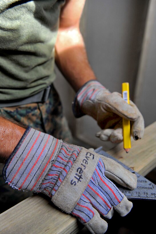 U.S. Marine Corps Cpl. Joe Everetts marks a piece of wood before cutting it to size at the Santa Marta engineering site during a Continuing Promise 2011 community service event in Puerto San Jose, Guatemala, July 2, 2011. Everetts is assigned to the 8th Engineer Battalion.