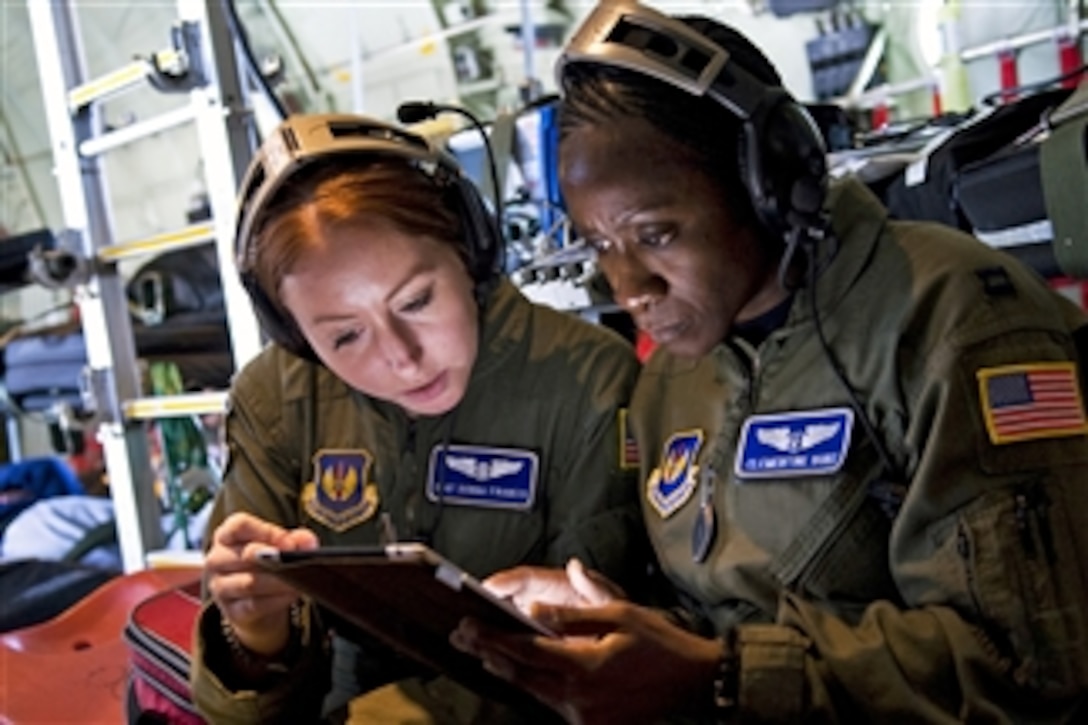 U.S. Air Force Staff Sgt. Donna Francis, an aeromedical evacuation technician, and flight nurse Capt. Clementine Duke, both with the 86th Aeromedical Evacuation Squadron, review Air Force Instructions aboard an C-130J Hercules during a flight from Ramstein Air Base, Germany, to Tbilisi, Georgia, on June 30, 2011.  