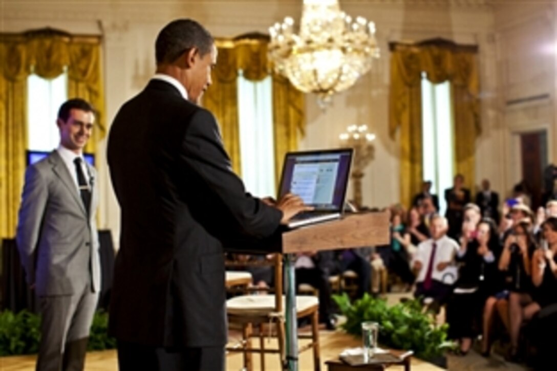 President Barack Obama tweets a question during the Twitter Town Hall in the East Room of the White House, July 6, 2011. Obama said U.S. security and strategic needs must drive impending defense spending cuts. Jack Dorsey, left, Twitter co-founder and executive chairman, moderated the event. 