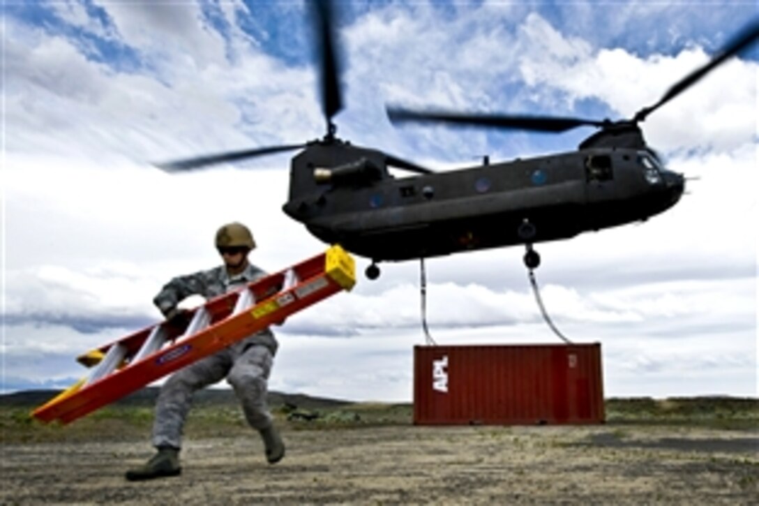 U.S. Air Force Staff Sgt. Jeremy Lowe carries a ladder from a storage container a CH-47 Chinook helicopter is transporting during a sling-load training exercise at the Senator Harry Reid Readiness and Training Center in Stead, Nev., June 28, 2011. Lowe is an airborne vehicle equipment operator craftsman assigned to the 820th Red Horse Squadron, and the CH-47 crew is assigned to the 1st Battalion, 189th Aviation Company, Nevada Army National Guard.