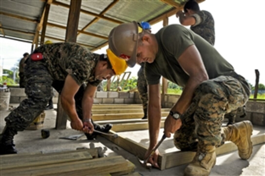 U.S. Marine Corps Cpl. Joe Everetts, right, and a Guatemalan Army engineer, left, frame a new classroom wall at the Santa Marta engineering site during a Continuing Promise 2011 community service event in Puerto San Jose, Guatemala, July 2, 2011. Everetts is assigned to the 8th Engineer Battalion. Continuing Promise is a five-month humanitarian assistance mission to the Caribbean, Central and South America.