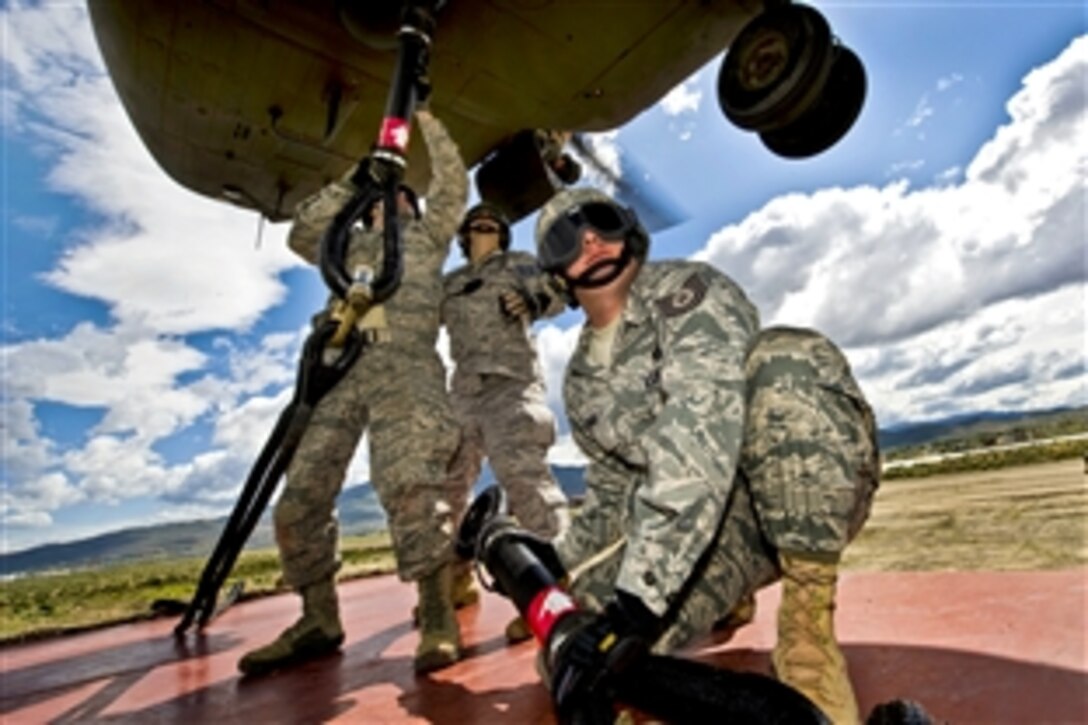 U.S. Air Force Tech. Sgt. Chris Kruze, front, stands by while Staff Sgts. Troy Hollis and Jeremy Lowe rig a storage container to a CH-47 Chinook helicopter during a sling-load training exercise at the Senator Harry Reid Readiness and Training Center in Stead, Nev., June 28, 2011. Kruze is an airborne vehicle equipment craftsman, Hollis is an airborne vehicle maintenance journeyman, and Lowe is a vehicle equipment craftsman. Kruze, Hollis and Lowe are assigned to the 820th Red Horse Squadron.