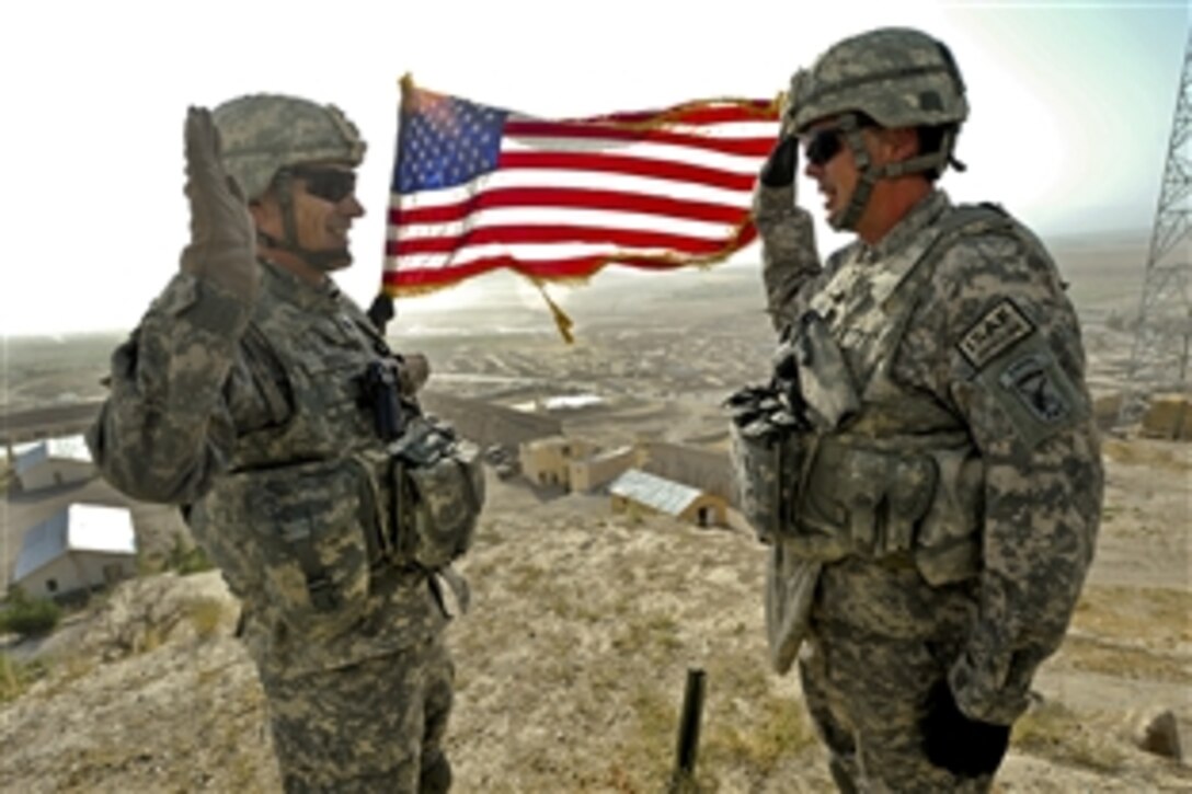 U.S. Air Force Lt. Col. Andy Veres, left, Provincial Reconstruction Team Zabul commander, re-enlists Master Sgt. James Sandifer, Forward Operating Base Smart mayor, on top of Alexander's castle in Qalat City, Afghanistan, July 7, 2011.