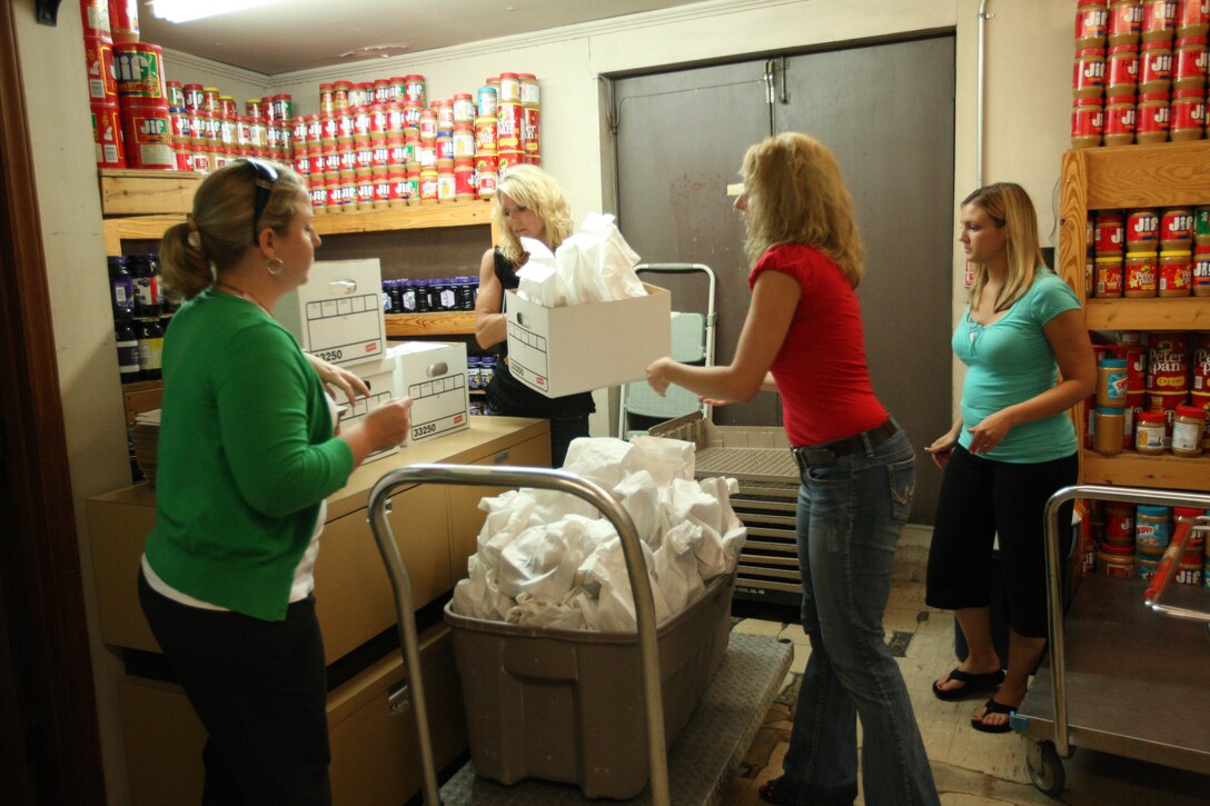 Staff with Atlantic Marine Corps Communities and Lend Lease packed 200 lunch bags at the AMCC conference room aboard Marine Corps Base Camp Lejeune, July 8. The bags were given to the Onslow Community Outreach soup kitchen and the funding for the food supplies was provided by the Lend Lease foundation. (Official U.S. Marine Corps photo by Pfc. Nik S. Phongsisattanak)
