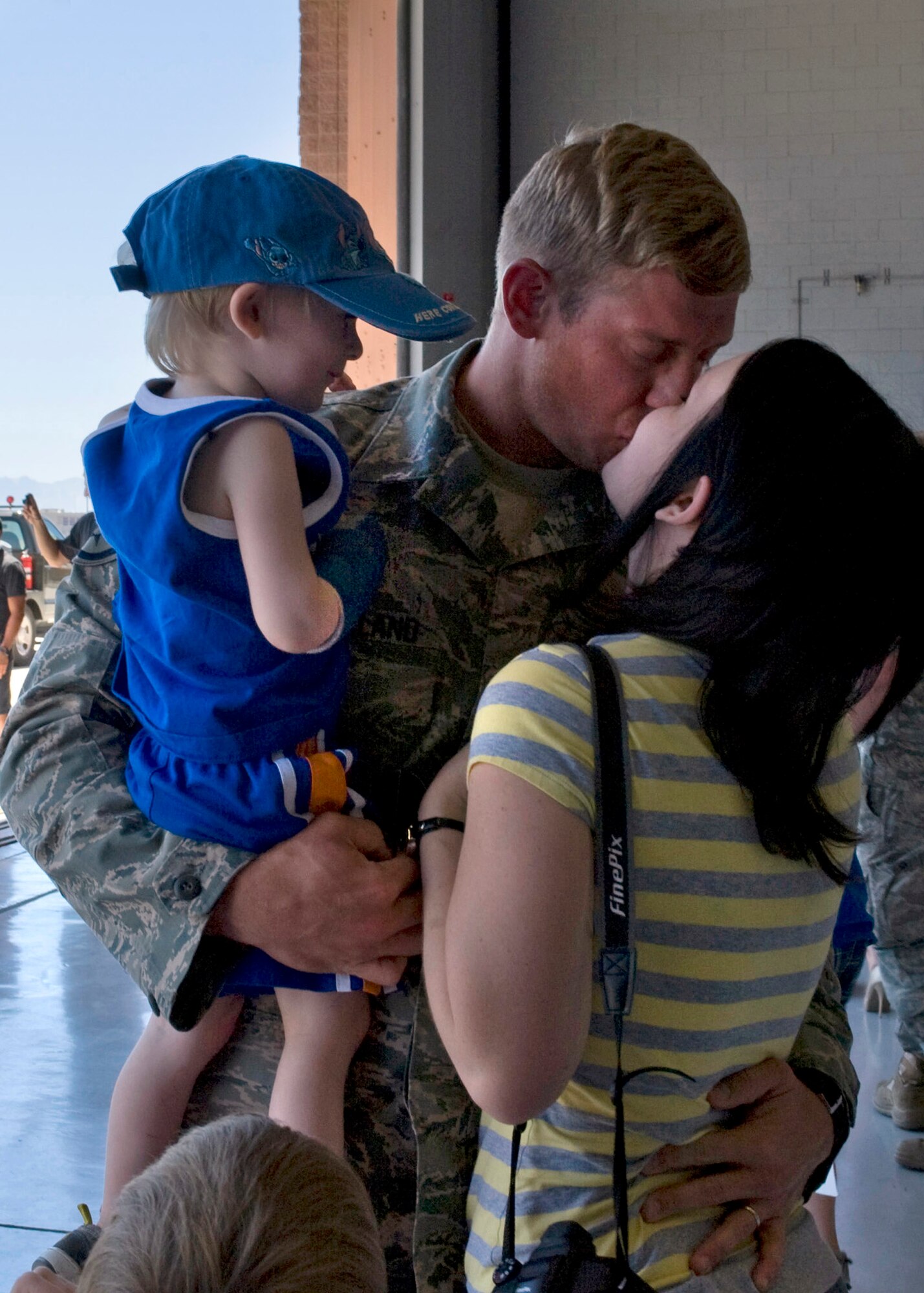 U.S. Air Force Staff Sgt. Daniel Strickland, 763rd Maintenance Squadron HH-60G Pave Hawk helicopter crew chief, embraces his wife, Melissa, and their son during the 763 MXS homecoming June 26, 2011, at Nellis Air Force Base, Nev.   Strickland and 48 fellow squadron members returned home from a 149-day deployment to Balad, Iraq, where they maintained combat search and rescue helicopters in support of Operation New Dawn. (U.S. Air Force photo by Airman 1st Class Matthew Lancaster/Released)
