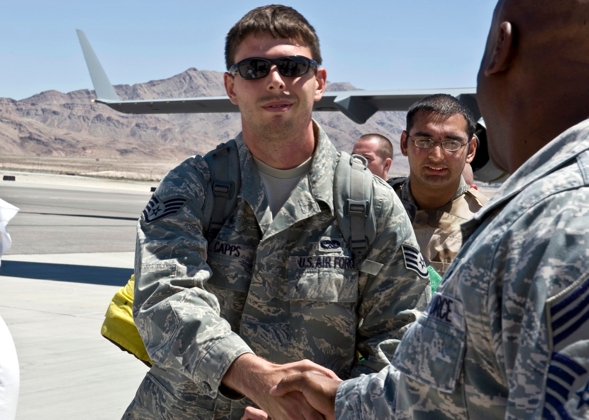 U.S. Air Force Staff Sgt. Danny Capps, 763rd Maintenance Squadron electronic countermeasures journeyman, left, shakes hands with Chief Master Sgt. Wesley Johnson,  763 MXS, superintendent, during the sqaudrons homecoming June 26, 2011, at Nellis Air Force Base, Nev.   Capps and 48 fellow squadron members returned home from a 149-day deployment to Balad, Iraq, where they maintained combat search and rescue helicopters in support of Operation New Dawn. (U.S. Air Force photo by Airman 1st Class Matthew Lancaster/Released)
