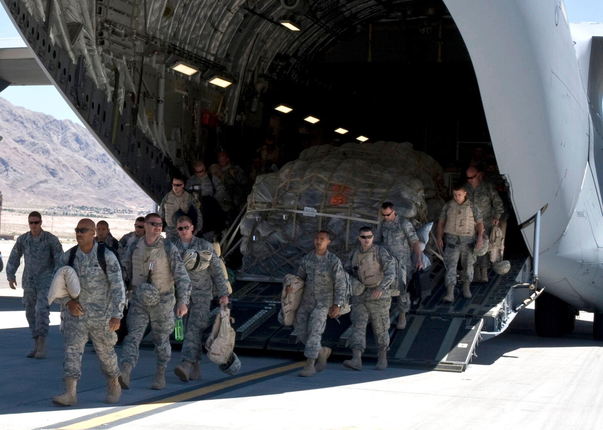 U.S. Air Force Airmen assigned to the 763rd Maintenance Squadron step off a C-17 Globemaster III June 26, 2011, at Nellis Air Force Base, Nev.  The 49 Airmen returned home from a 149-day deployment to Balad, Iraq, where they maintained combat search and rescue helicopters in support of Operation New Dawn. (U.S. Air Force photo by Airman 1st Class Matthew Lancaster/Released)



