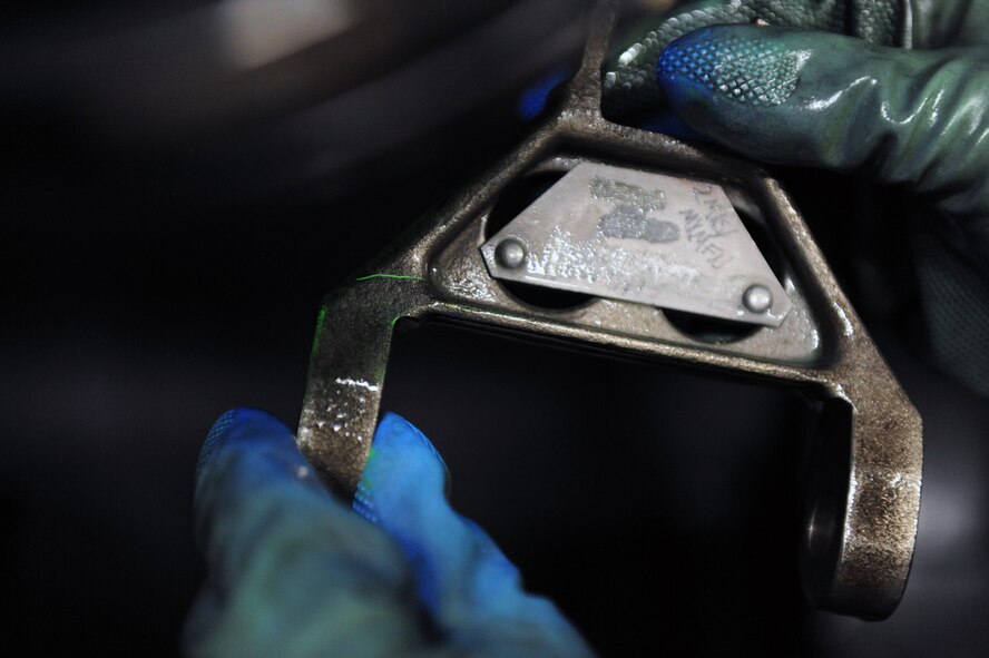 Airman 1st Class Paul Nessle, 2nd Maintenance Squadron, inspects a part for scratches, dings and gashes in the 2nd Propulsion Flight building on Barksdale Air Force Base, La., July 8. A special magnetic fluorescent dye is poured over the part and reveals any imperfections. (U.S. Air Force photo/Airman 1st Class Micaiah Anthony)(RELEASED) 