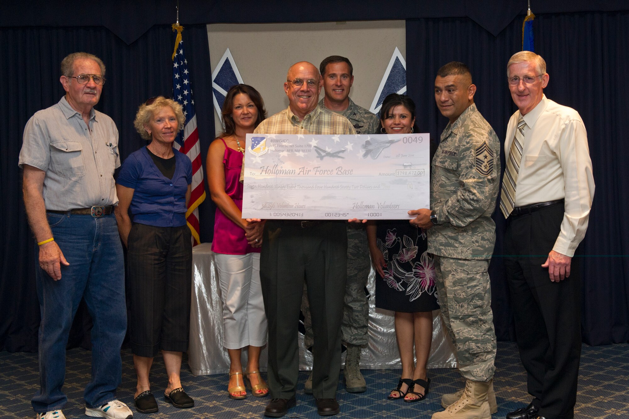 HOLLOMAN AIR FORCE BASE, N.M. -- Col. David Krumm, 49th Wing commander and Chief Master Sgt. Gerardo Tapia, 49th Wing command chief, receive a check from the Airman and Family Readiness Center, June 28, 2011 during the annual Volunteer Recognition Ceremony. The check represents 38,296 hours that 163 volunteers from Team Holloman have accumulated between April 2010 and April 2011. The Volunteer Recognition Ceremony was held to show appreciation to Team Holloman volunteers. (U.S. Air Force photo by Airman 1st Class Joshua Turner / Released)