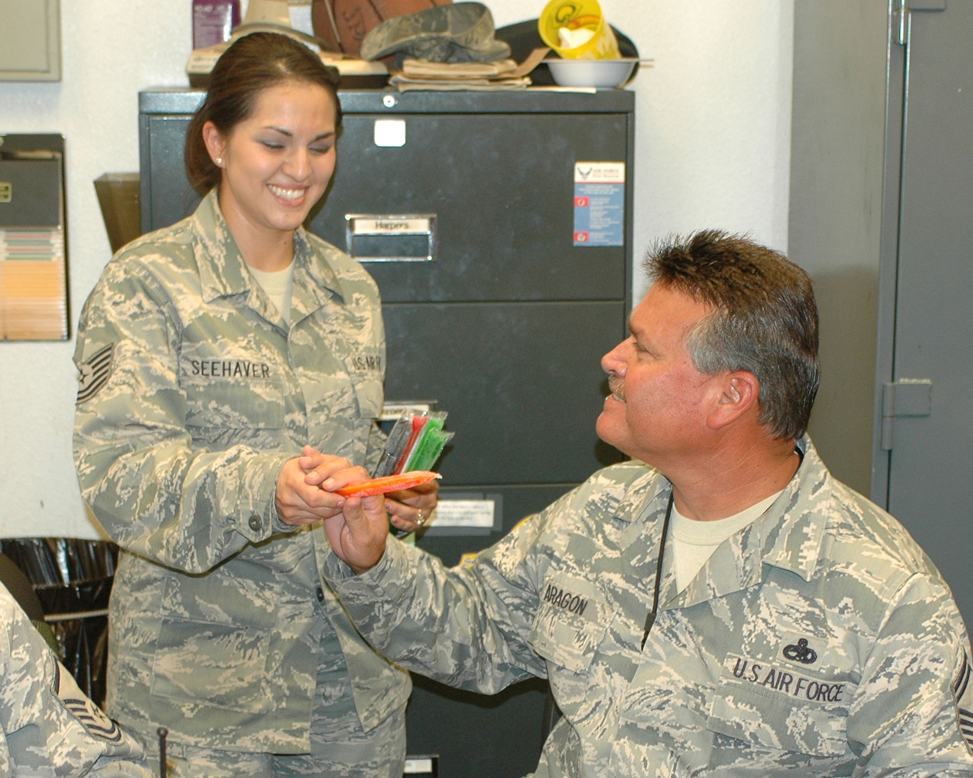 Tech. Sgt. Erica Seehaver, vice president, Junior Enlisted Council, hands out frozen popsicles to maintainers in Hanger 10 during their lunch break.  (U.S. Air Force photo/Staff Sgt. Jordan Jones)
