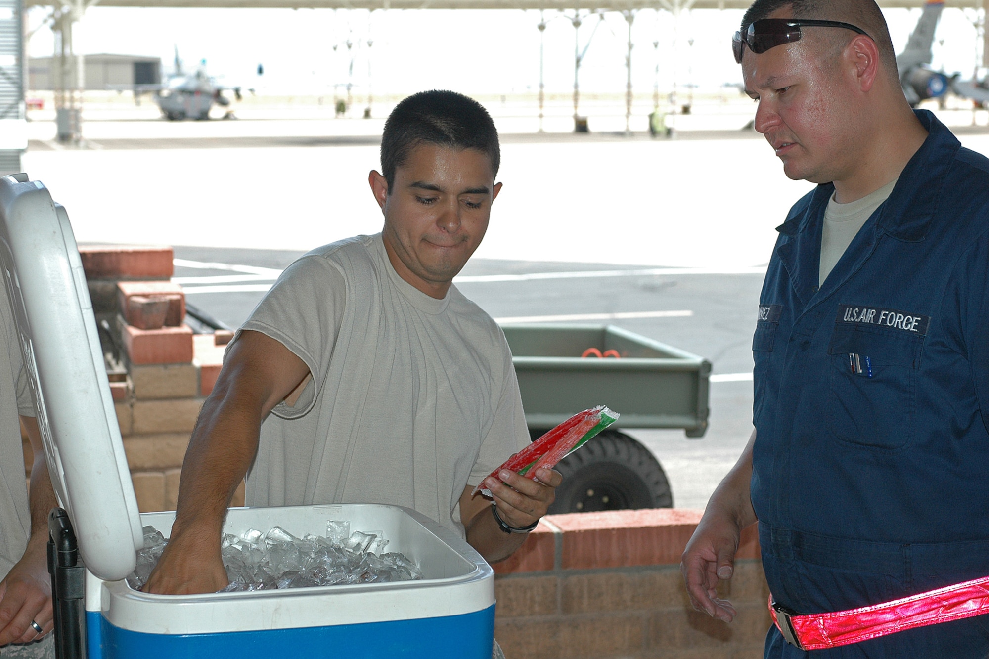 Tech. Sgt. Isreal Montoya, treasurer, Junior Enlisted Council, gathers frozen popsicles to give to Guardsmen working in the 100 degree Tucson heat and boost moral July 8. (U.S. Air Force photo/Staff Sgt. Jordan Jones)
