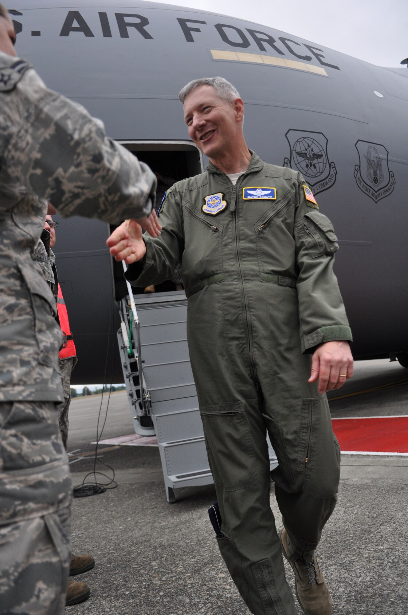 Brig. Gen. Wayne Schatz, left, Air Mobility Command Director of Strategic Plans, Requirements and Programs, greets Airmen after delivering McChord Field’s newest C-17 Globemaster III July 7 at Joint Base Lewis-McChord, Wash. (U.S. Air Force photo/Airman 1st Class Leah Young)
