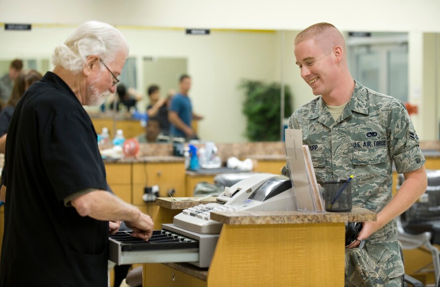 Larry DeMars gives change to one of his regulars, Airman 1st Class Austin Groupp, 2nd Maintenance Squadron, after a haircut at the main barbershop in the Base Exchange on Barksdale Air Force Base, La., July 8. DeMars has cut hair here for more than 30 years. (U.S. Air Force photo/Senior Airman Chad Warren)(RELEASED)