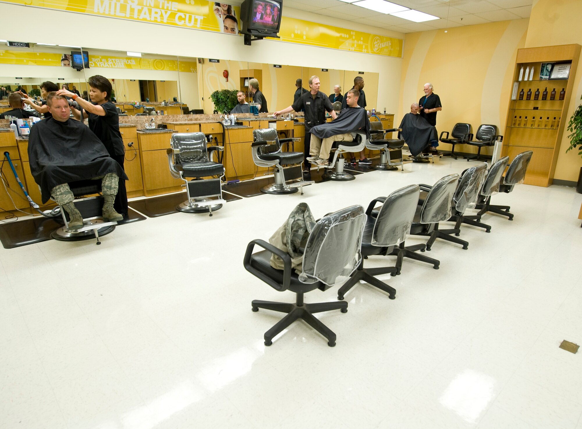 Several barbers cut hair at the main barbershop in the Base Exchange on Barksdale Air Force Base, La., July 7, 2011. Larry DeMars, far right, has been a barber here for more than 30 years. (U.S. Air Force photo/Senior Airman Chad Warren)(RELEASED)