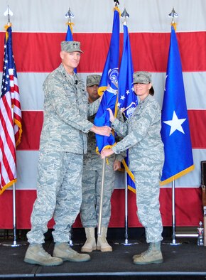 Maj. Gen. Andrew Busch, Ogden Air Logistics Center commander, gives the 75th Air Base Wing guidon to Col. Sarah Zabel, 75th ABW commander, as Chief Master Sgt. Max Grindstaff, command chief for the OO-ALC and 75th ABW, stands nearby at the change of command ceremony June 30. Zabel's predecessor, Col. Patrick Higby, will now serve in a position with the White House Communications Agency, headquartered in Washington, D.C. (U.S. Air Force photo by Kim Cook)