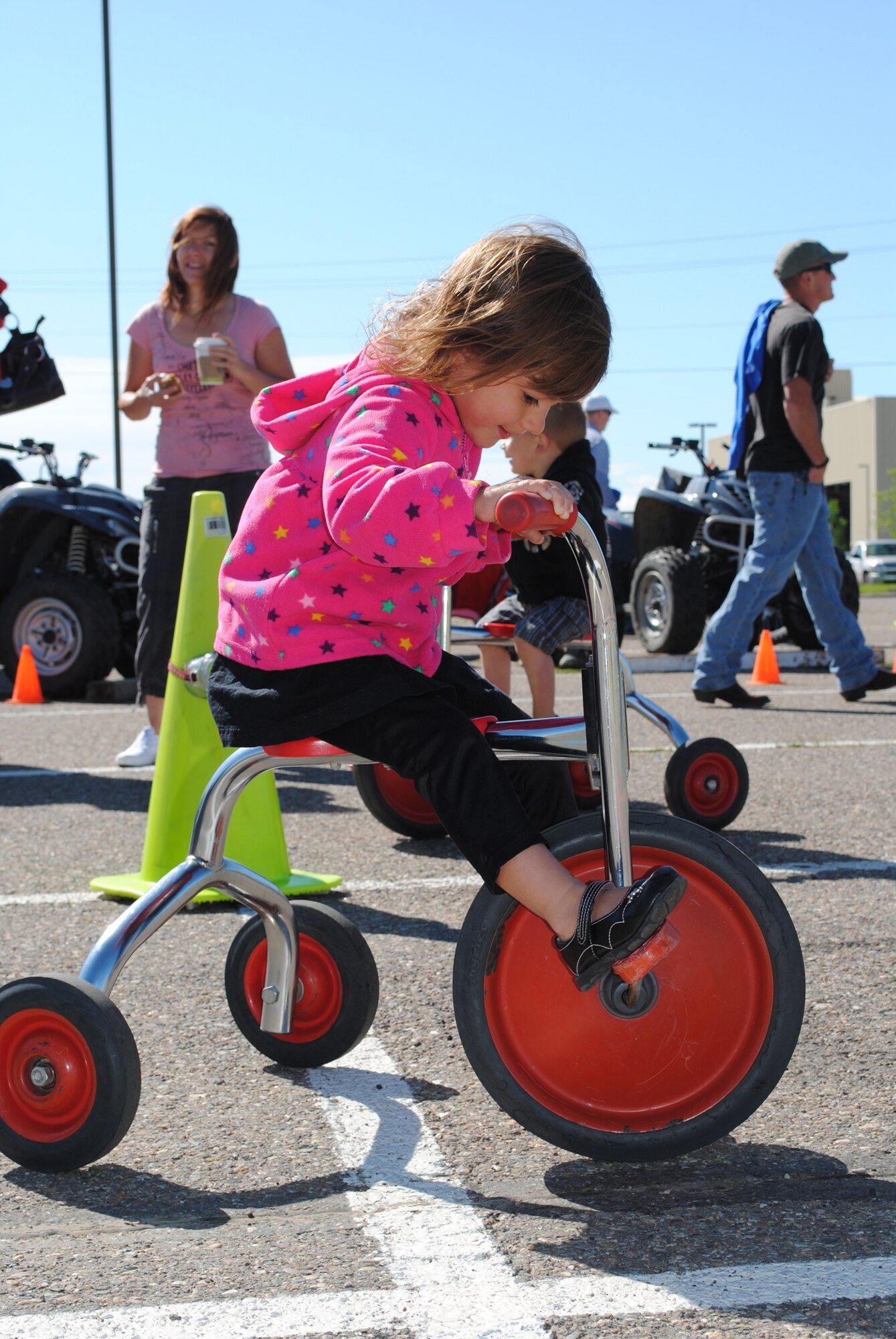 Three-year-old Lila Martinez takes a spin on a tricycle during the Rolling Thunder motorcycle event June 30.  (U.S. Air Force photo/Airman 1st Class Katrina Heikkinen)