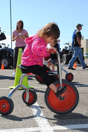 Three-year-old Lila Martinez takes a spin on a tricycle during the Rolling Thunder motorcycle event June 30.  (U.S. Air Force photo/Airman 1st Class Katrina Heikkinen)