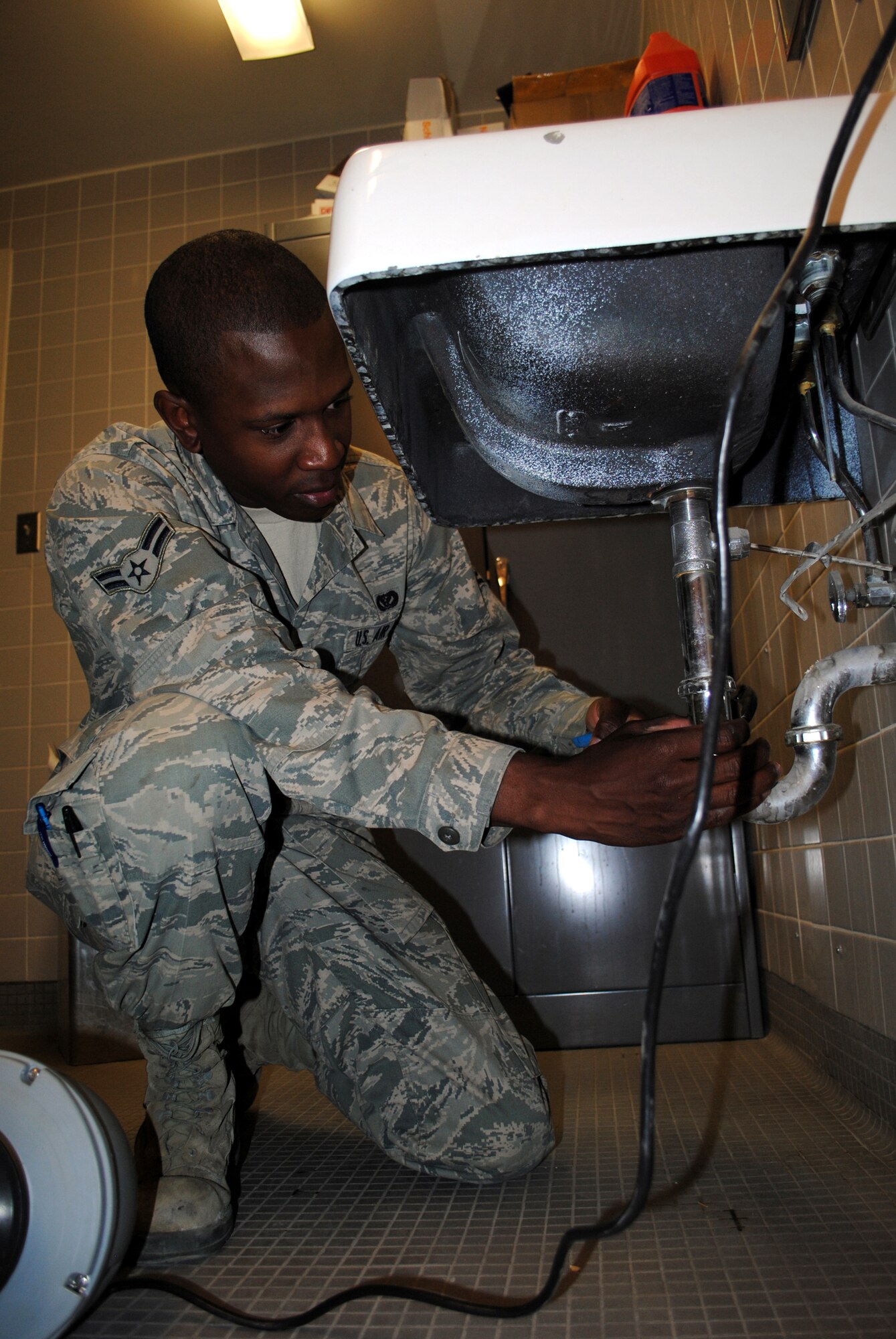 Airman 1st Class Lionel Dumas, 341st Civil Engineer Squadron water and fuel systems apprentice, prepares to remove a piece of pipe to fix a clogged sink.  Sinks are one of many things he fixes on a daily basis.  (U.S. Air Force photo/Airman Cortney Paxton)