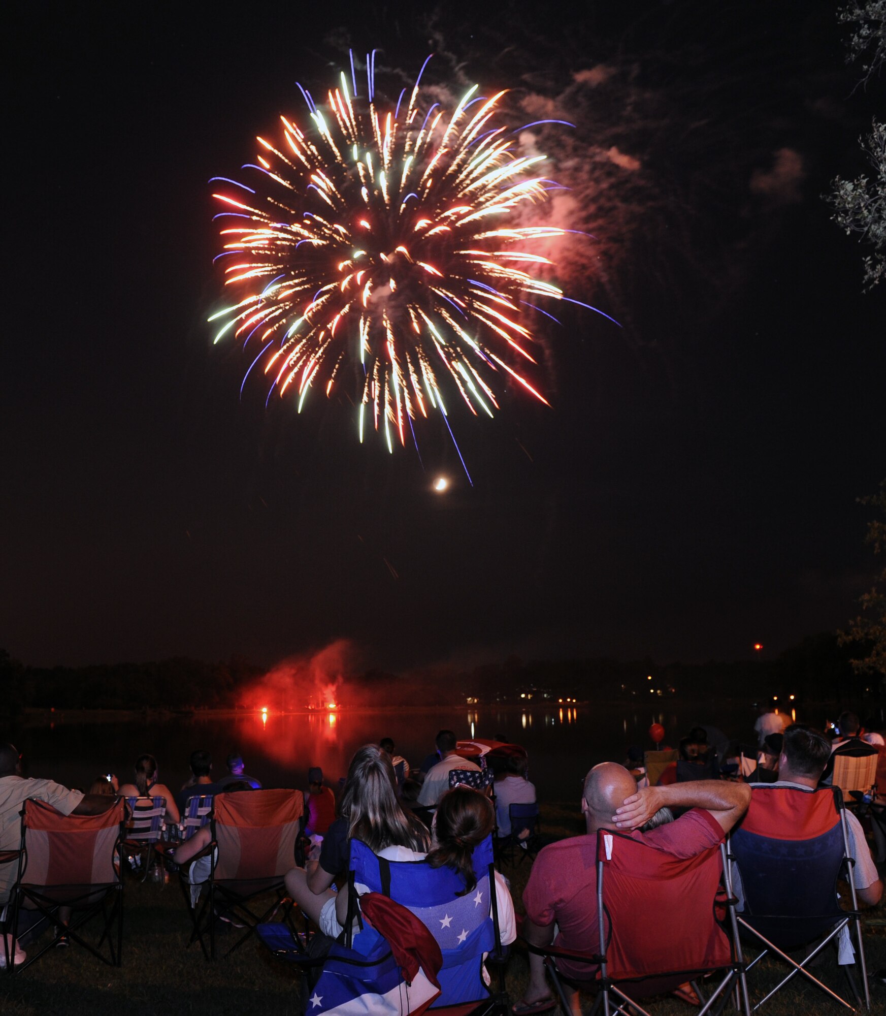 Team Little Rock members, families and friends watch the fireworks display during the Fourth of July celebration at Little Rock Air Force Base, Ark. The fireworks display capped off an afternoon of activities including the Air Mobility Command Icon contest, games and a family parade.  (U.S. Air Force photo by Airman 1st Class Rusty Frank)