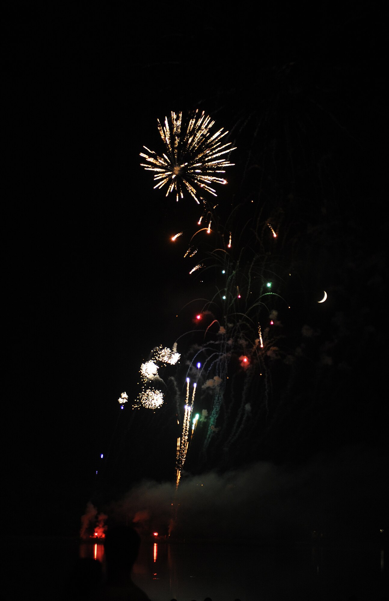 Families gather around the base lake to watch a fireworks show on July 4, 2011, at Little Rock Air Force Base, Ark. The fireworks display capped off an afternoon of activities including the Air Mobility Command Icon contest, games and a family parade.   (U.S. Air Force photo by Airman 1st Class Ellora Remington)