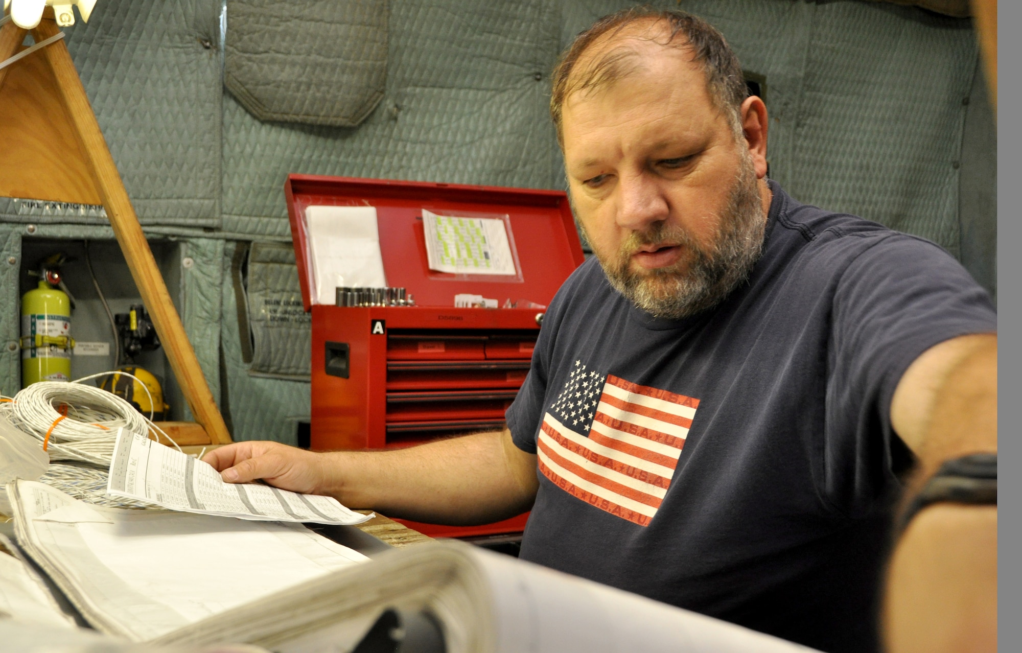 Jim Dorigatti, electrician, checks wire bundle against wiring diagrams June 27 on a workbench inside a C-5 Galaxy.