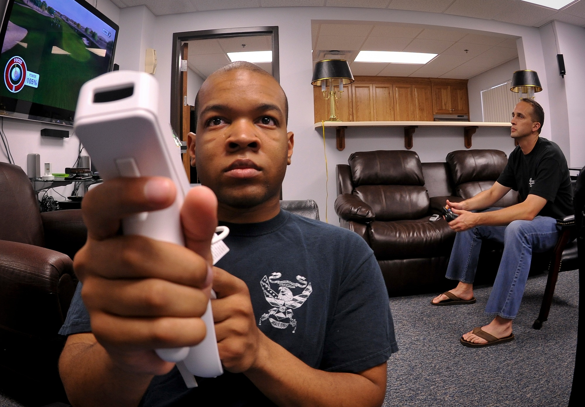 U.S. Air Force Airman 1st Class Fredrick Simpson, 23rd Equipment Maintenance Squadron nondestructive inspection journeyman, plays Call of Duty on the Nintendo Wii as Chaplain (Capt.) David Daus, 23rd Wing Protestant chaplain, plays a round of golf on Tiger Woods PGA Tour 11 at the Komodo Center at Moody Air Force Base, Ga., July 6, 2011. The newly-relocated Komodo Center is now in Bldg. 573. (U.S. Air Force photo by Airman 1st Class Joshua Green/Released)
