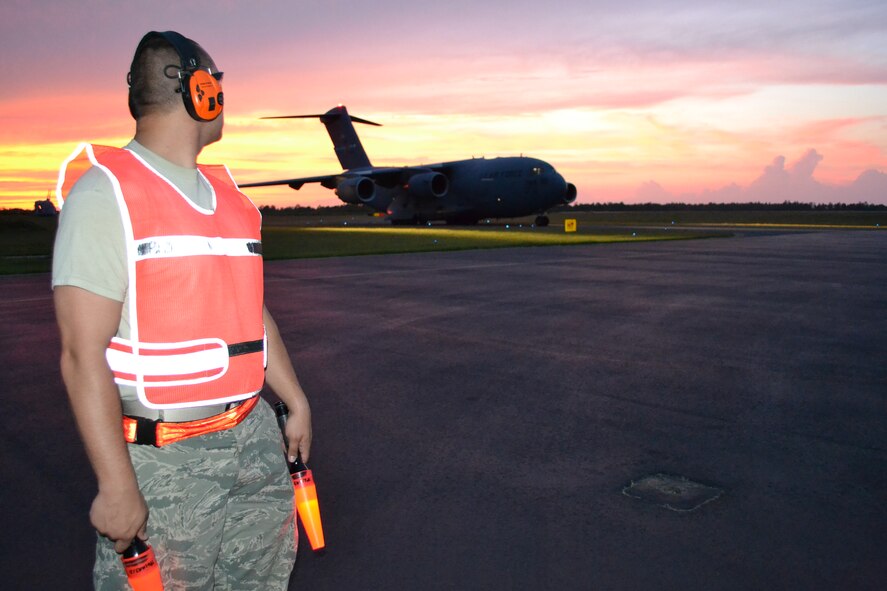 Staff Sgt. Jordan Slaughter, 615th Contingency Response Wing, waits to guide in a C-17 Globemaster III as it lands on the evening of June 24, 2011. (U.S. Army photo/ 1st Lt. Andrea Whitaker)
