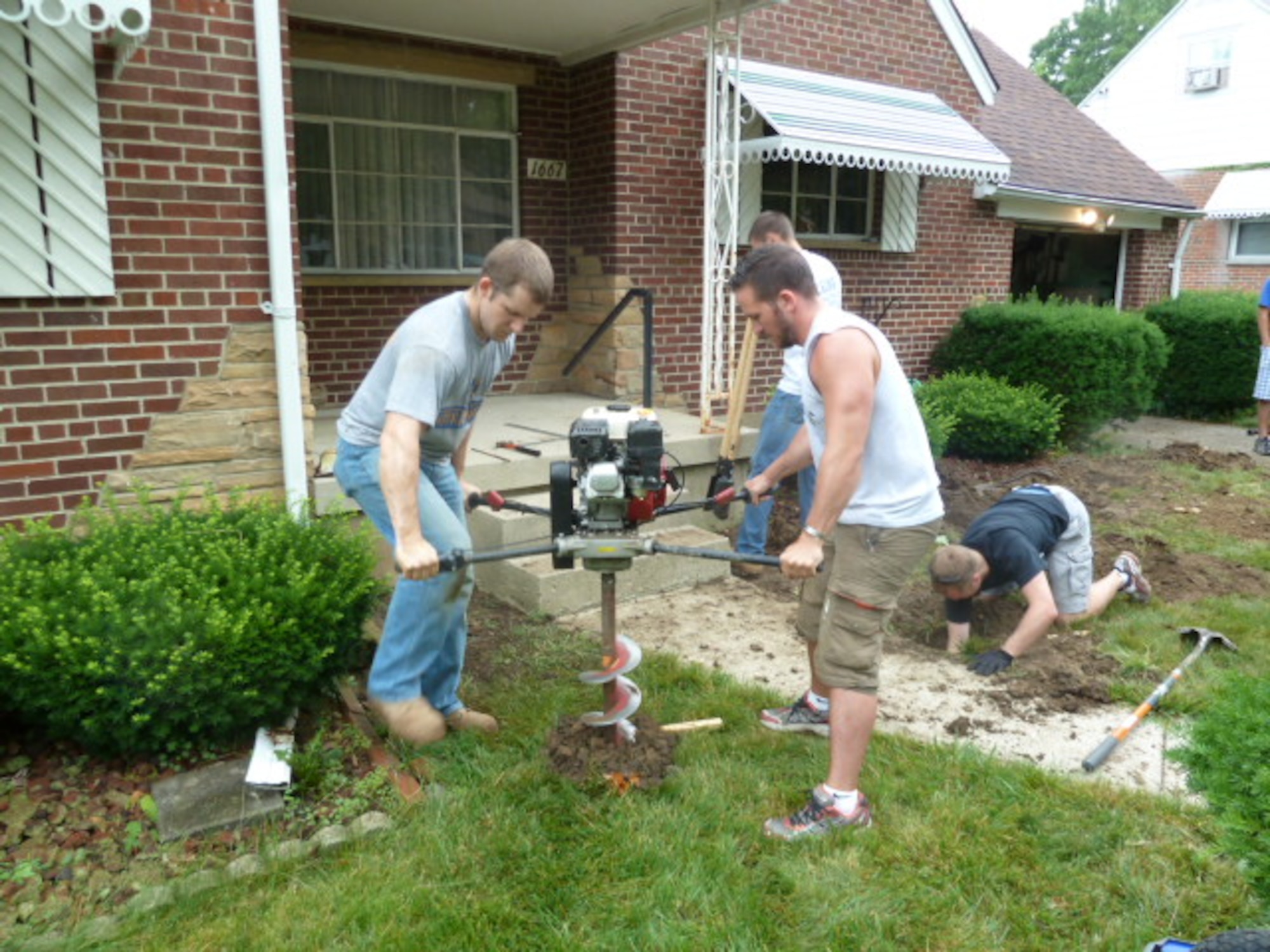 Capt. James Rozzoni and 1st Lt. Kevin Ochs use an auger to dig holes for the support posts.  