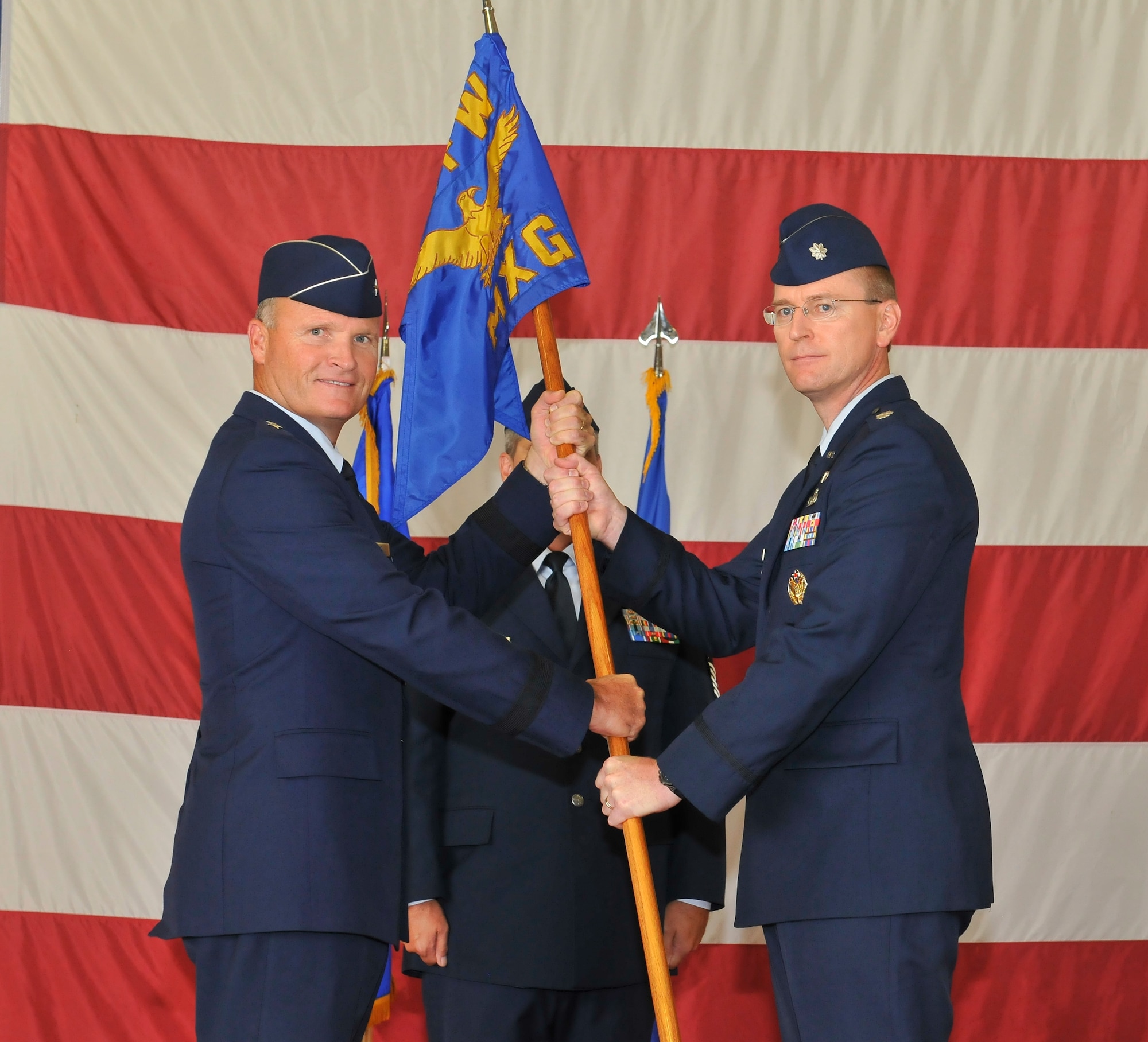 Brigadier Gen. James S. Browne, 325th Fighter Wing commander, passes command of the 325th Maintenance Group to Lt. Col. Curtis Hafer during a change of command ceremony July 8. Colonel Hafer replaces Col. Craig Hall who departs Tyndall to serve as the Director of Maintenance Logistics at Headquarters Air Education and Training Command Randolph Air Force Base, Texas. Colonel Hafer arrives from Washington D.C., where he attended the Industrial College of the Armed Forces, Fort Lesley J. McNair. (U.S. Air Force photo by Lisa Norman)