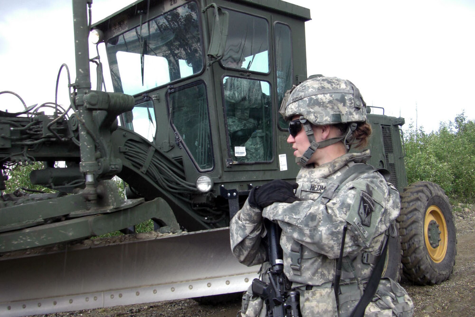 Army 1st Lt. Megan Hedman of 84th Engineer Support Company (Airborne), 6th Engineer Battalion (Combat) (Airborne), supervises a Soldier operating a 130G Grader during a construction project on Donnelly Training Area at Fort Greely during Operation Tundra Wolf. The outpost road improvement project converted a fair-weather trail into an all-weather road, making the route safe to travel year round. (Photo by Lt. Col. Marc Hoffmeister/6th Engineer Battalion) 
