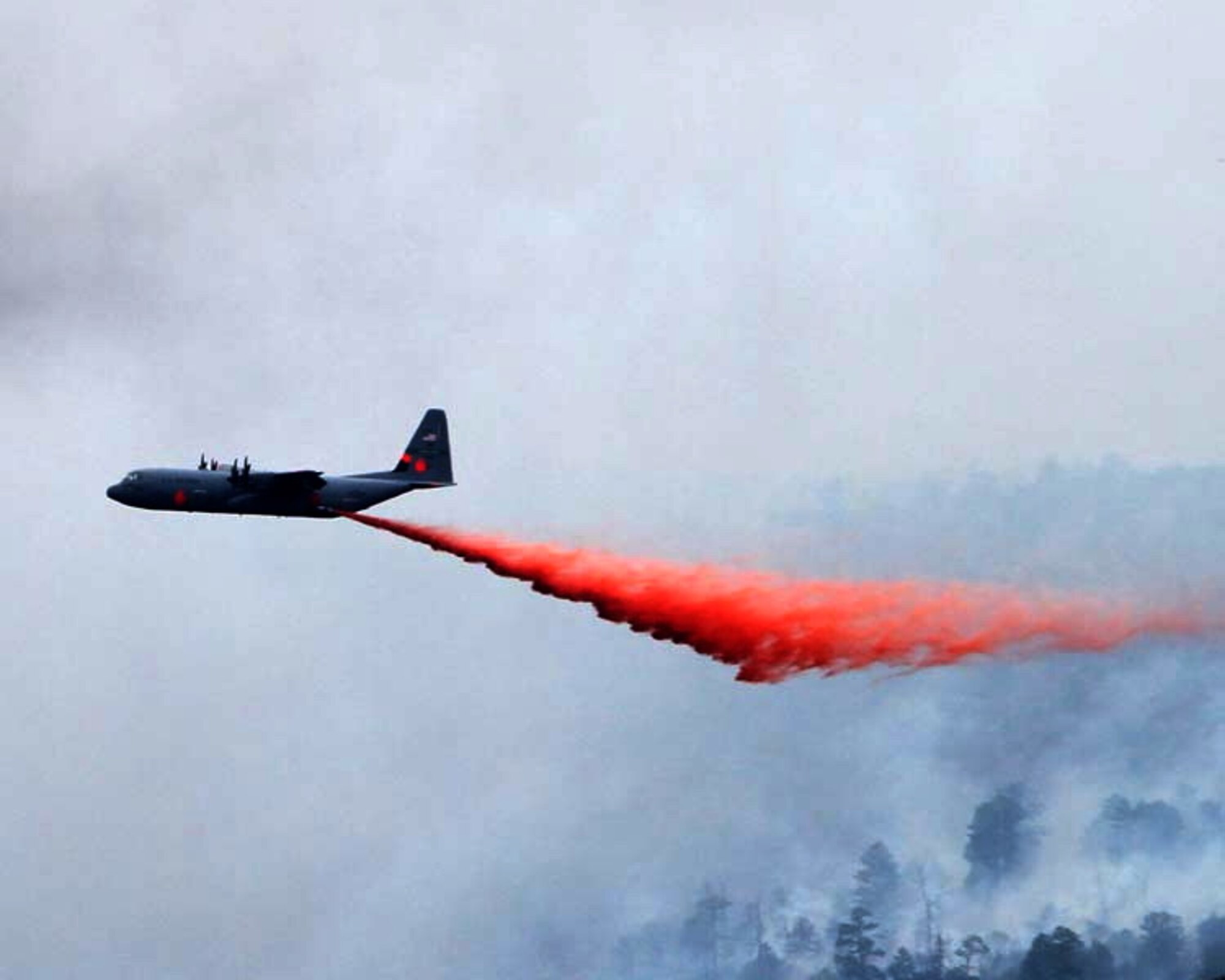 A C-130 Modular Airborne Fire Fighting System-equipped aircraft performs a fire drop onto the Las Conchas on July 2. The MAFFS is one of four assigned to the 302nd Air Expeditionary Group to fight numerous wildfires in the Southwestern United States. Courtesy Photo by Jason Coil