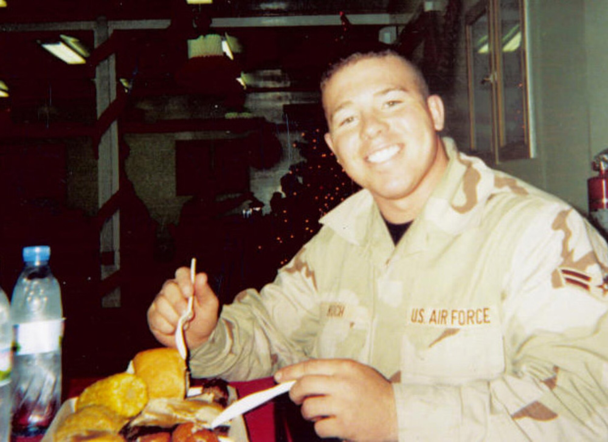 DAVIS-MONTHAN AIR FORCE BASE, Ariz. - Staff Sgt. Shawn Koch, 355th Aircraft Maintenance Squadron, aircraft fuel systems craftsman shift non-commissioned officer in charge – then, Airman 1st Class Koch – enjoys his Thanksgiving dinner during his first deployment to Afghanistan in 2003. (Courtesy photo)