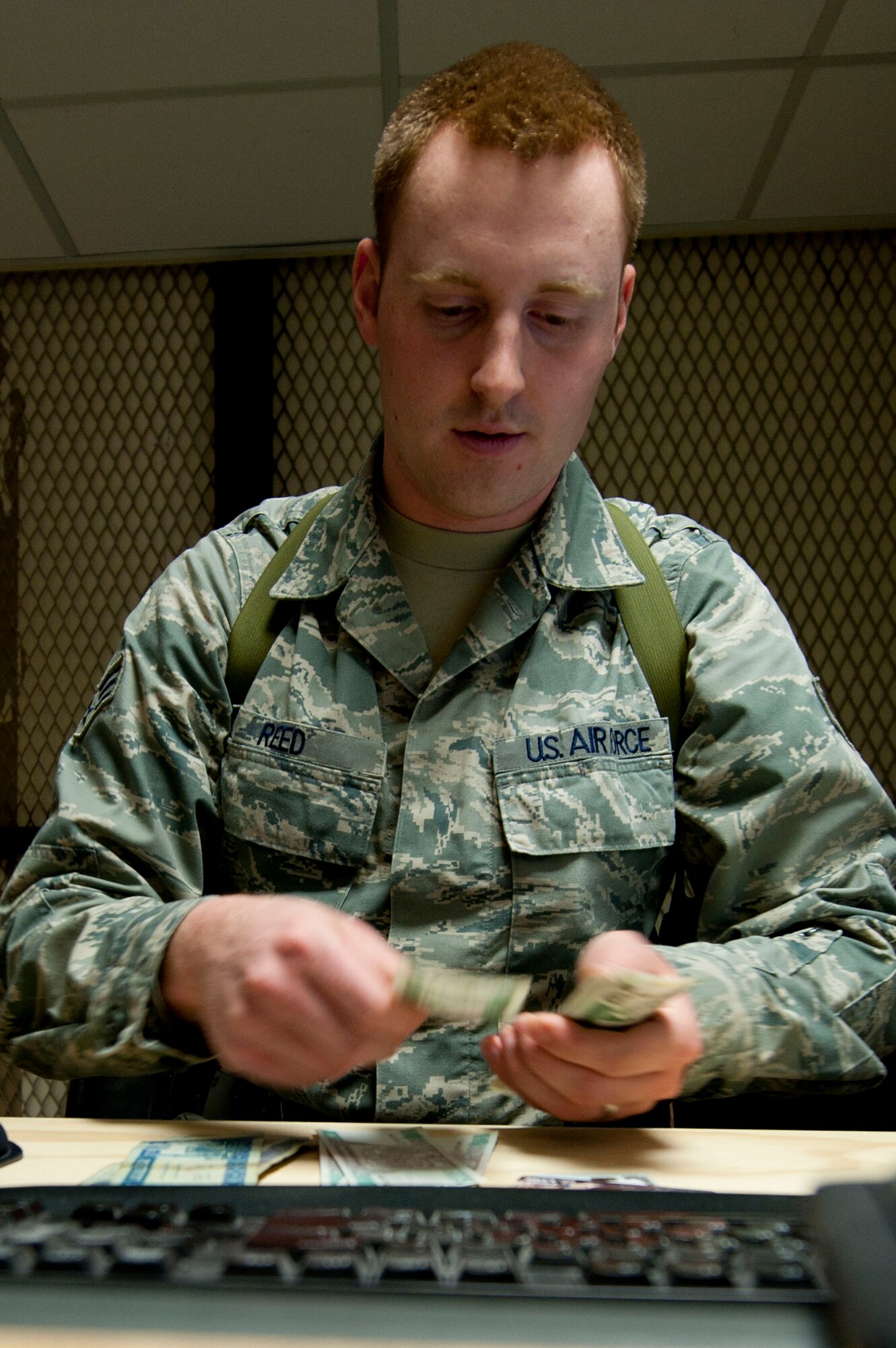 Senior Airman James Reed, 451st Air Expeditionary Wing finance cashier, counts Afghani at Kandahar Air Field, Afghanistan, July 8, 2011. Senior Airman Reed is deployed from Little Rock Air Force Base, AR. (U.S. Air Force photo by Senior Airman Corey Hook)
