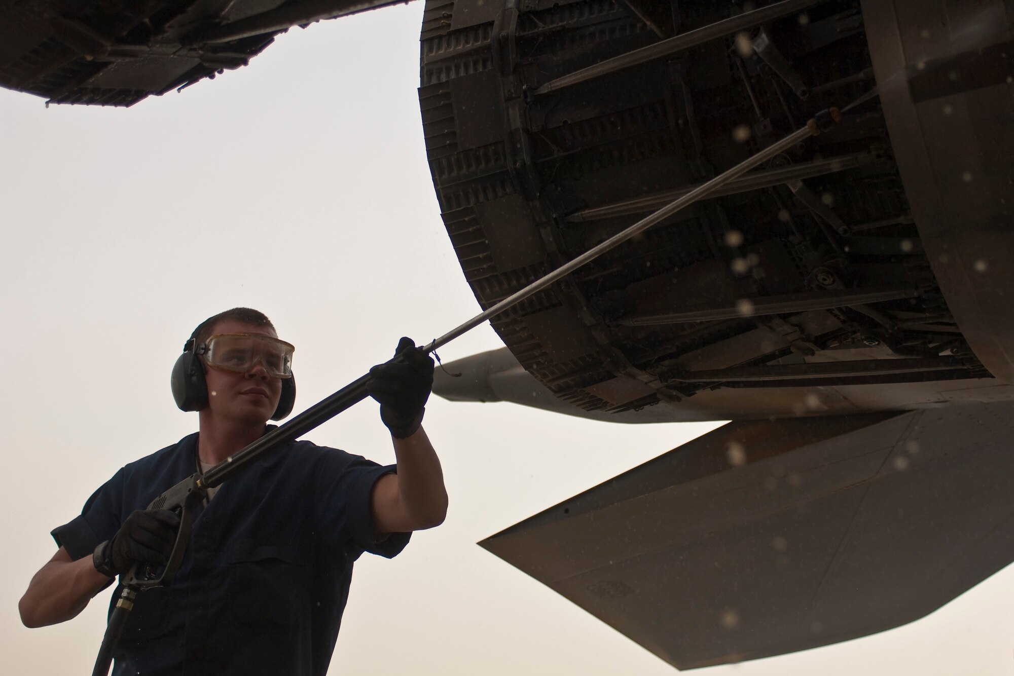 BAGRAM AIRFIELD, Afghanistan -- Staff Sgt. Brandon Beatt, 455th Expeditionary Aircraft Maintenance Squadron crew chief, pressure washes accumulated dust from an F-15E Strike Eagle after a dust storm here June 26.  Sergeant Beatt is currently deployed from 389th Aircraft Maintenance Squadron at Mountain Home Air Force Base, Idaho. (U.S. Air Force photo by Staff Sgt. Jorge Intriago)
