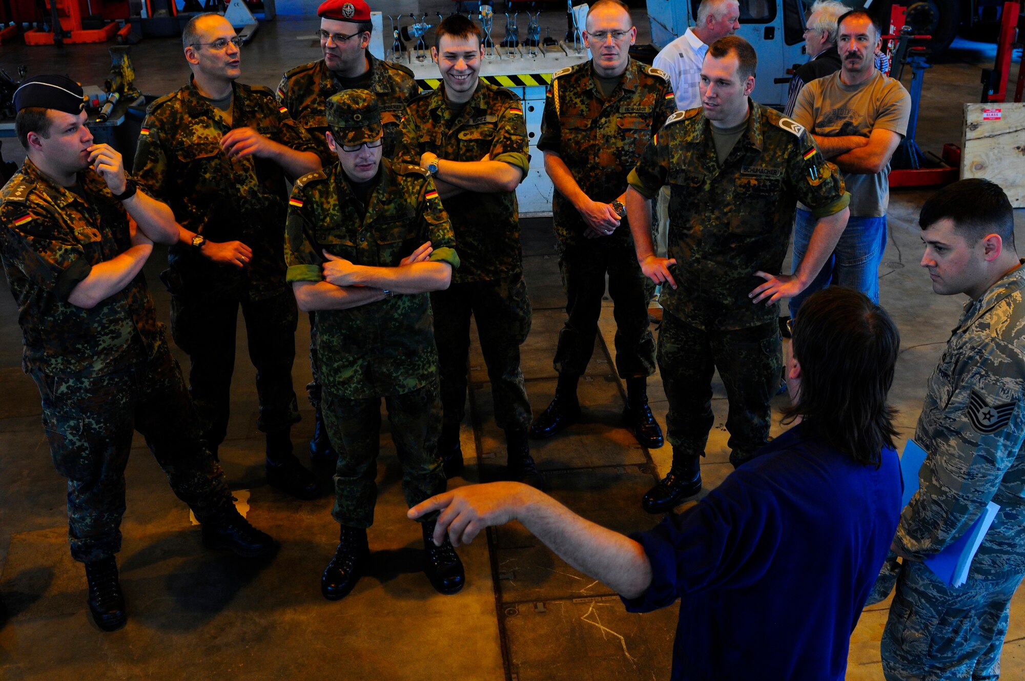 Herr Harlad Baron, 86th Vehicle Readiness Squadron mechanic, briefs German Armed Forces School of Logistics students, Ramstein Air Base, Germany, July 6, 2011. The German military members toured Ramstein to help them improve their skills to deliver additional logistics knowledge to their peers. (U.S. Air Force Photo by Airman 1st Class Brea Miller)  