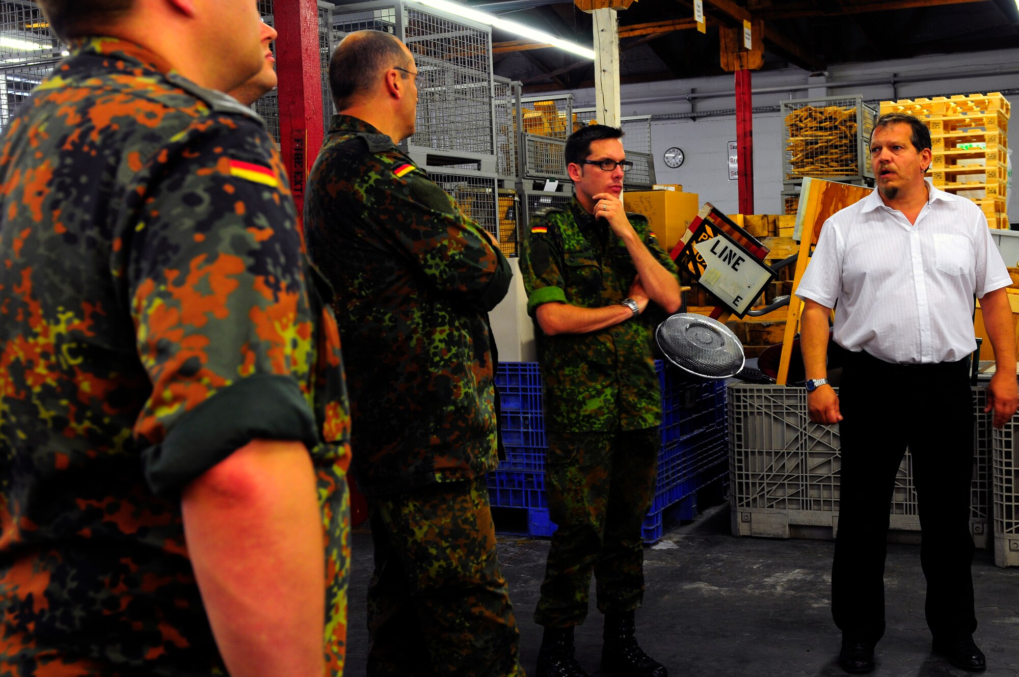 Herr Thomas Schmitt, 86th Logistics Readiness Squadron freight traffic manager, briefs German Armed Forces School of Logistics students, Ramstein Air Base, Germany, July 6, 2011. The German military members toured Ramstein to help them improve their skills to deliver additional logistics knowledge to their peers. (U.S. Air Force Photo by Airman 1st Class Brea Miller)  