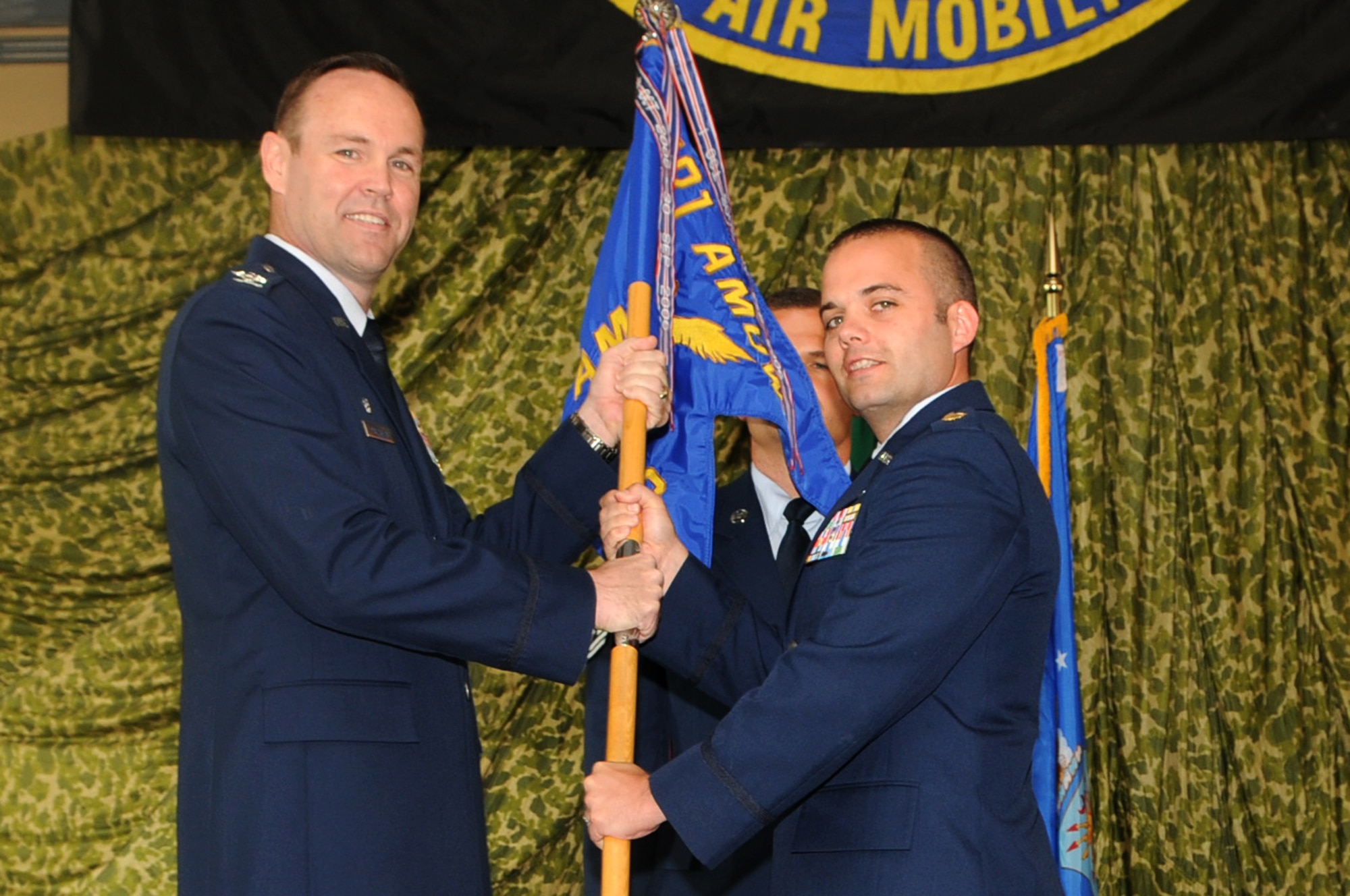 Col. James MacFarlane, 721st Air Mobility Operations Group commander from Ramstein Air Base, passes the 724th Air Mobility Squadron guidon to Maj. Ryan Norman during the 724th AMS change of command ceremony July 6 at Aviano Air Base, Italy. Norman assumed command of the 724th AMS from Lt. Col. Scott Belanger. Prior to assuming his current duties, Norman was a student at the Air Command and Staff College. (U.S. Air Force photo/Staff Sgt. Julius Delos Reyes)