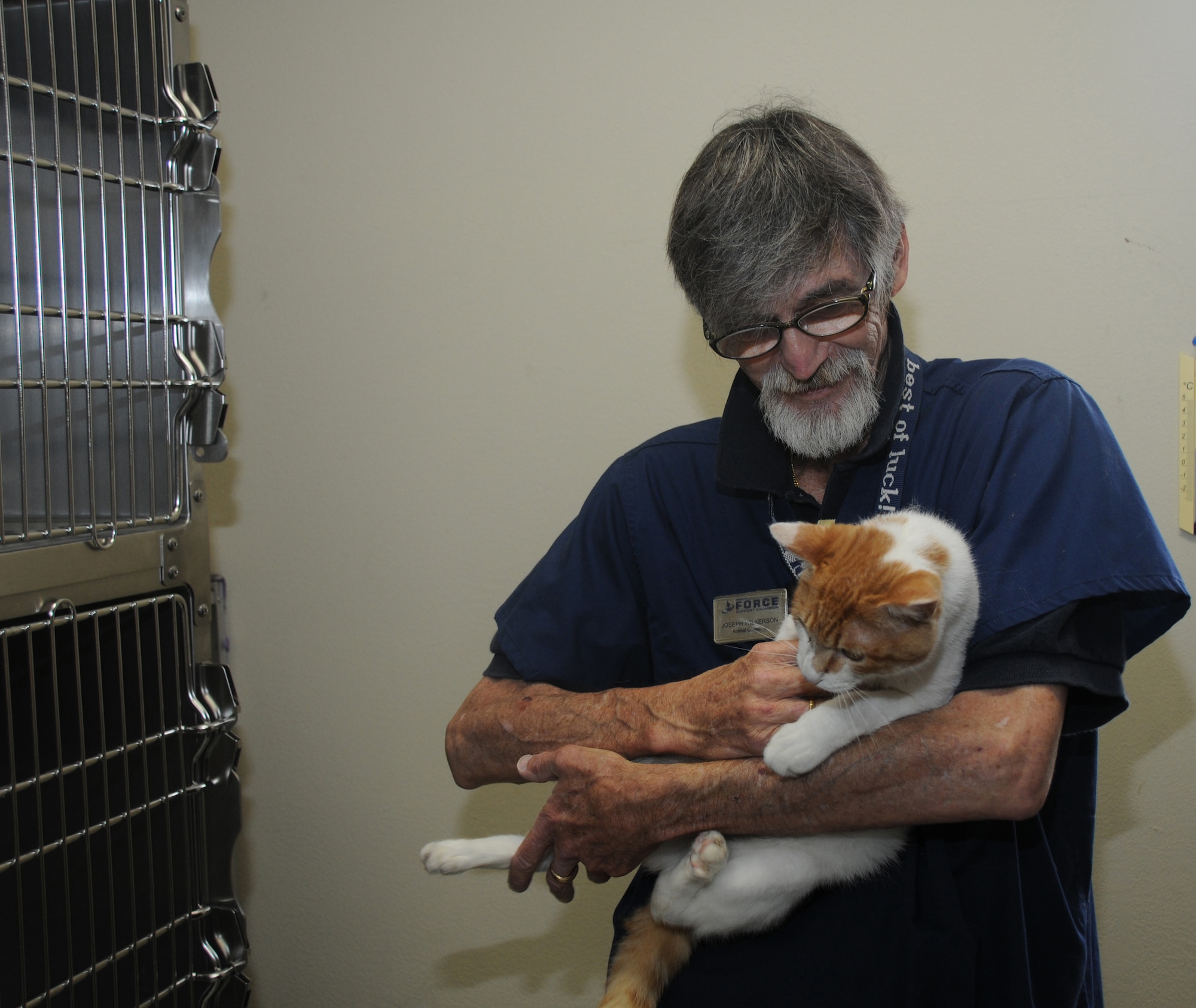 YOKOTA AIR BASE, Japan -- Joseph Wilkerson, Pet Care Center animal care taker, gives care and attention to Red, a stray cat, at Yokota Air Base, Japan, July 7, 2011. The center puts stray cats up for adoption after ensuring all of their health care needs are met. (U.S. Air Force photo/Airman John D. Partlow)