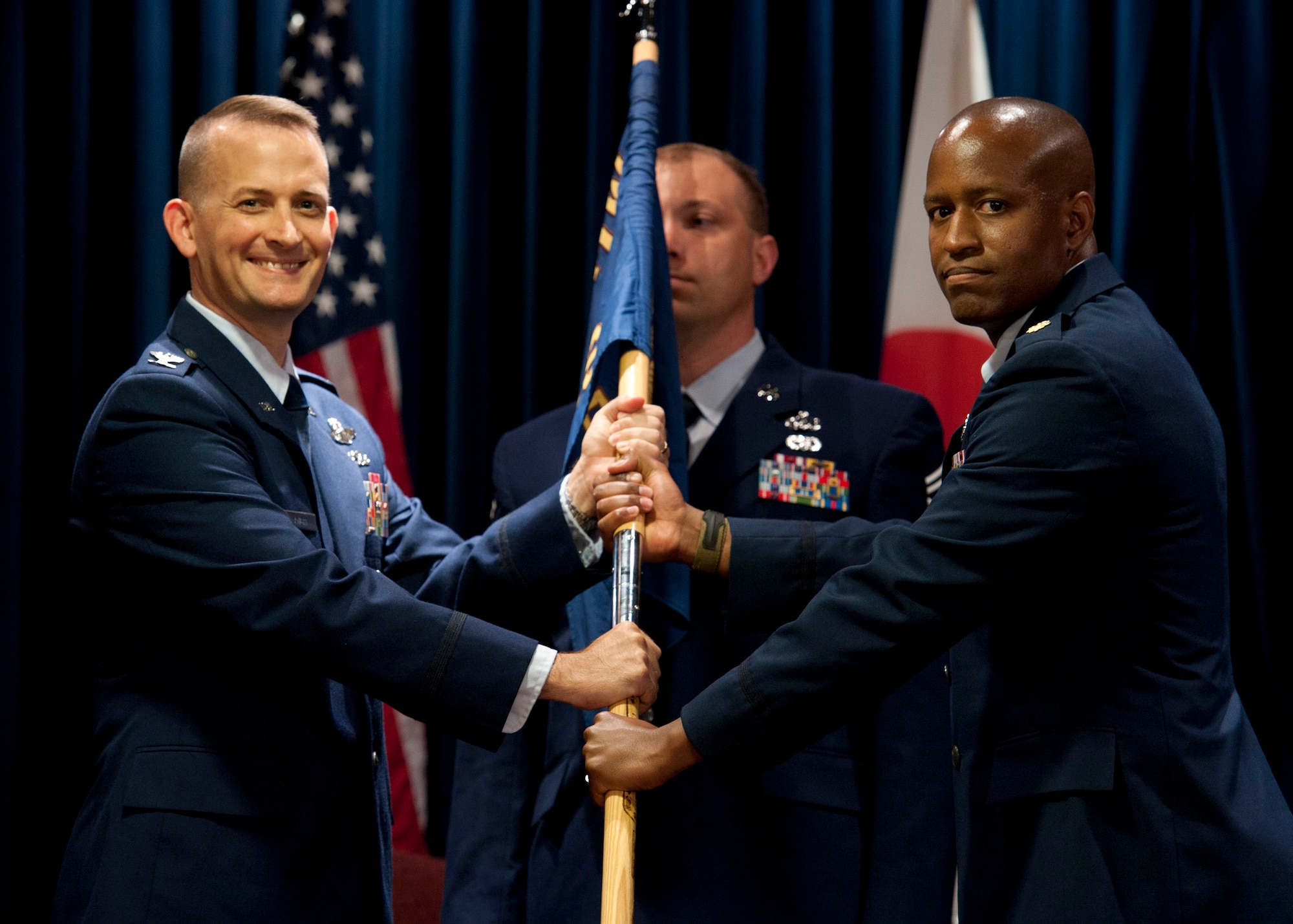 YOKOTA AIR BASE, Japan -- Col. Bill Knight, 374th Airlift Wing vice commander, presents the 374th Comptroller Squadron guideon to Maj. Ned June, signifying the start of Major June's command of the unit at Yokota Air Base, Japan, July 7, 2011. (U.S. Air Force photo/Staff Sgt. Samuel Morse)