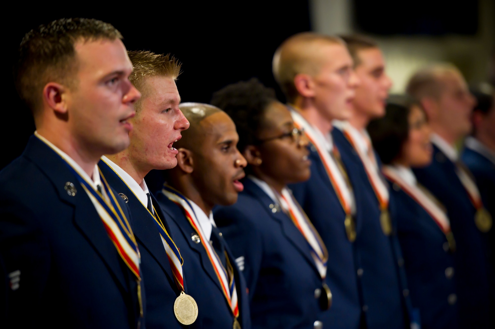 YOKOTA AIR BASE, Japan -- Staff Sgt. Mitchell Shulz (second from left), 374th Operations Support Squadron, sings the Air Force Song with his fellow classmates from Airman Leadership School Class 11-E at the conclusion of their graduation ceremony at Yokota Air Base, Japan, July 7, 2011. Sergeant Shulz was awarded the John L. Levitow Award, the highest award given in enlisted professional military education. (U.S. Air Force photo/Staff Sgt. Samuel Morse)