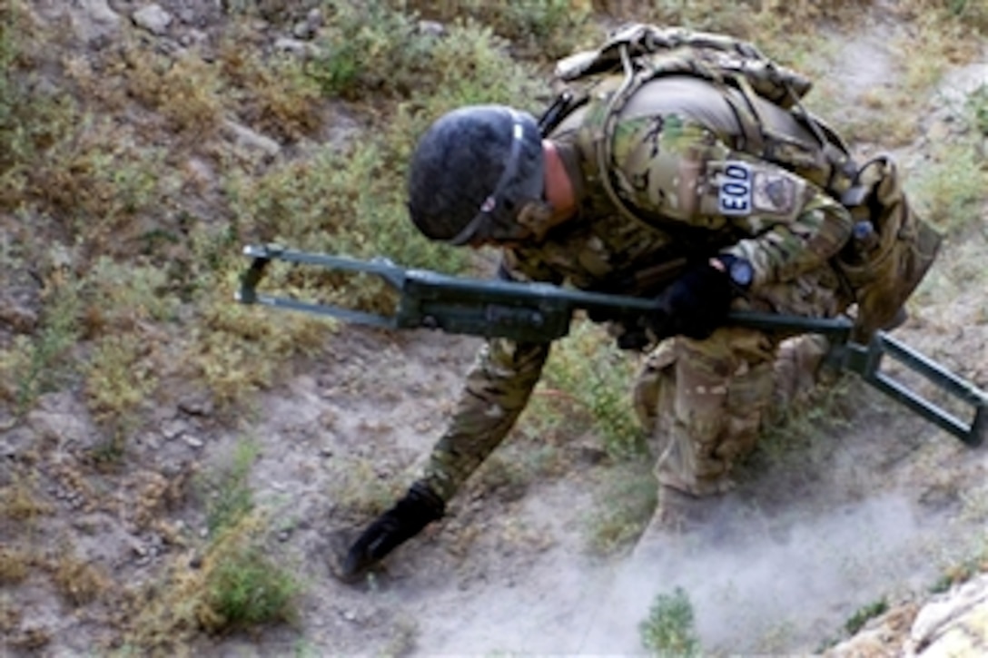 U.S. Air Force Master Sgt. Kevin Bullivant unearths explosive charges after using a metal detector to sweep the area for an improvised explosive device in the city of Jamal in Afghanistan's Ghazni province on June 29, 2011.  Bullivant is an explosive ordnance disposal technician assigned to the 466A Explosive Ordnance Disposal Team.  