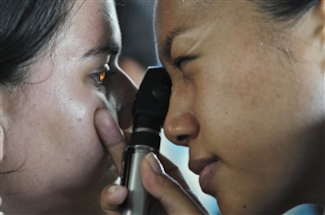U.S. Navy optometrist Lt. Patricia Salazar (right) looks into a patient's eye at the Los Angeles medical site in Puerto San Jose, Guatemala, during Continuing Promise 2011 on July 6, 2011.  Continuing Promise is a five-month humanitarian assistance mission to countries in the Caribbean, Central and South America.  