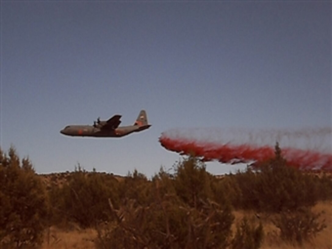 A California Air National Guard C-130 Hercules aircraft equipped with a modular airborne firefighting system drops fire retardant near Hondo, N.M., on June 28, 2011.  