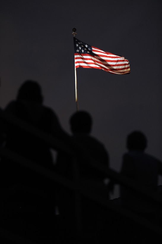 Spectators watch a Friday Evening Parade at Marine Barracks Washington as the 1801 Flag flies overhead July 8, 2011. The 1801 Flag is flown during Evening Parades, representing the era when the Barracks was founded. The flag features 15 stars and 15 stripes for the 15 states that were part of the union at the time. Fort McHenry, Md., is the only other location authorized to fly this flag.