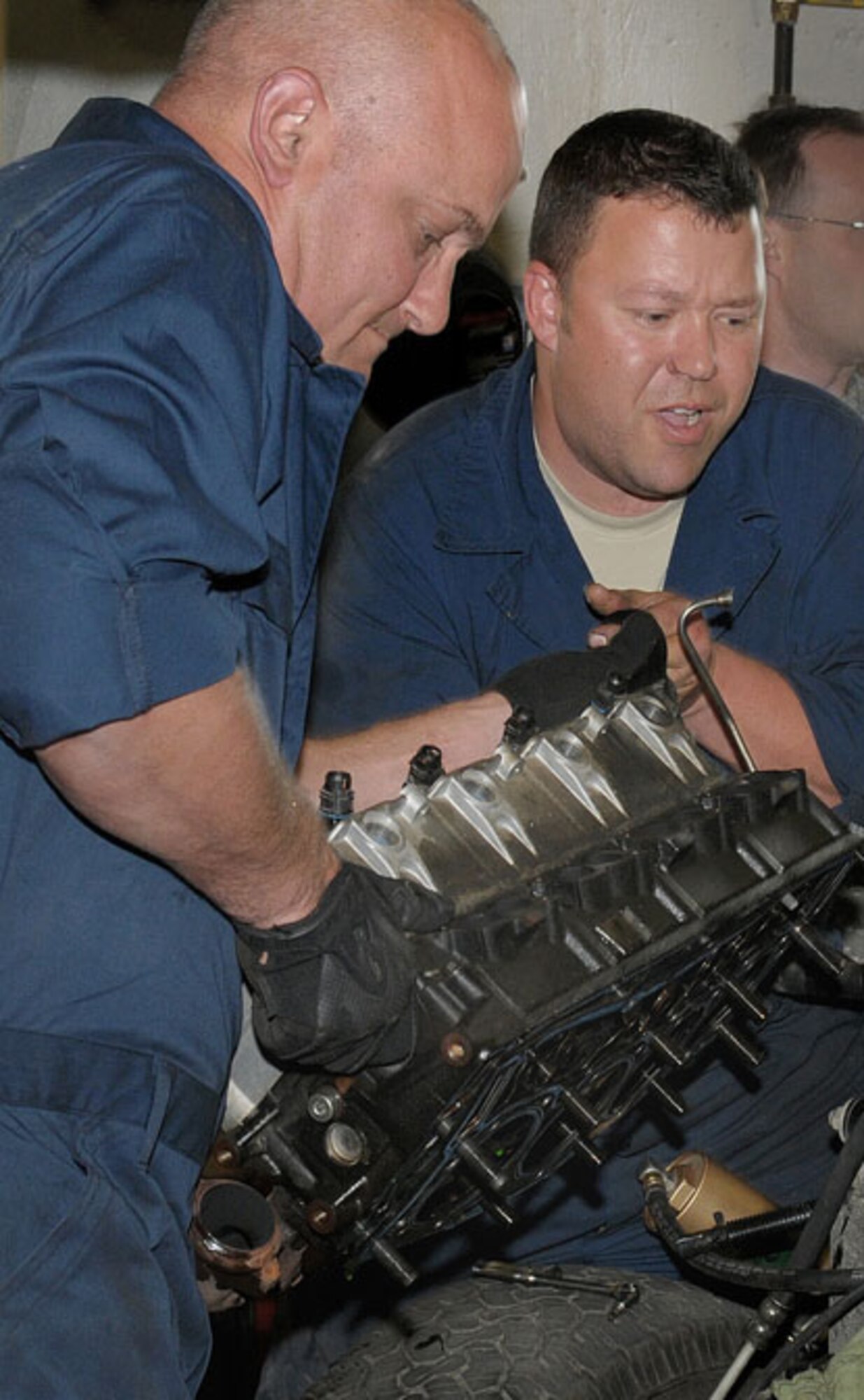 Staff Sergeaent Jeffrey Strong (left), Vehicle Maintenance, Logistics Readiness Squadron,146th Airlift Wing, Channel Islands Air National Guard Station, Calif., and Technical Sergeant Clint Miller (right), Vehicle Maintenance, 176th LRS, 176 Wing, Alaska Air National Guard, Joint Base Elmendorf-Richardson, Anchorage, Alaska, work to replace a cylinder head gasket on a Security Forces pickup on June 14, 2011. The 146th AW sent three squadrons to JBER from June 4 to June 18, 2011. The Air Terminal Operations Squadron, LRS, and Security Forces Squadron moved down range to complete their respective annual training requirements. Photo by Tech. Sgt. Alex Koenig