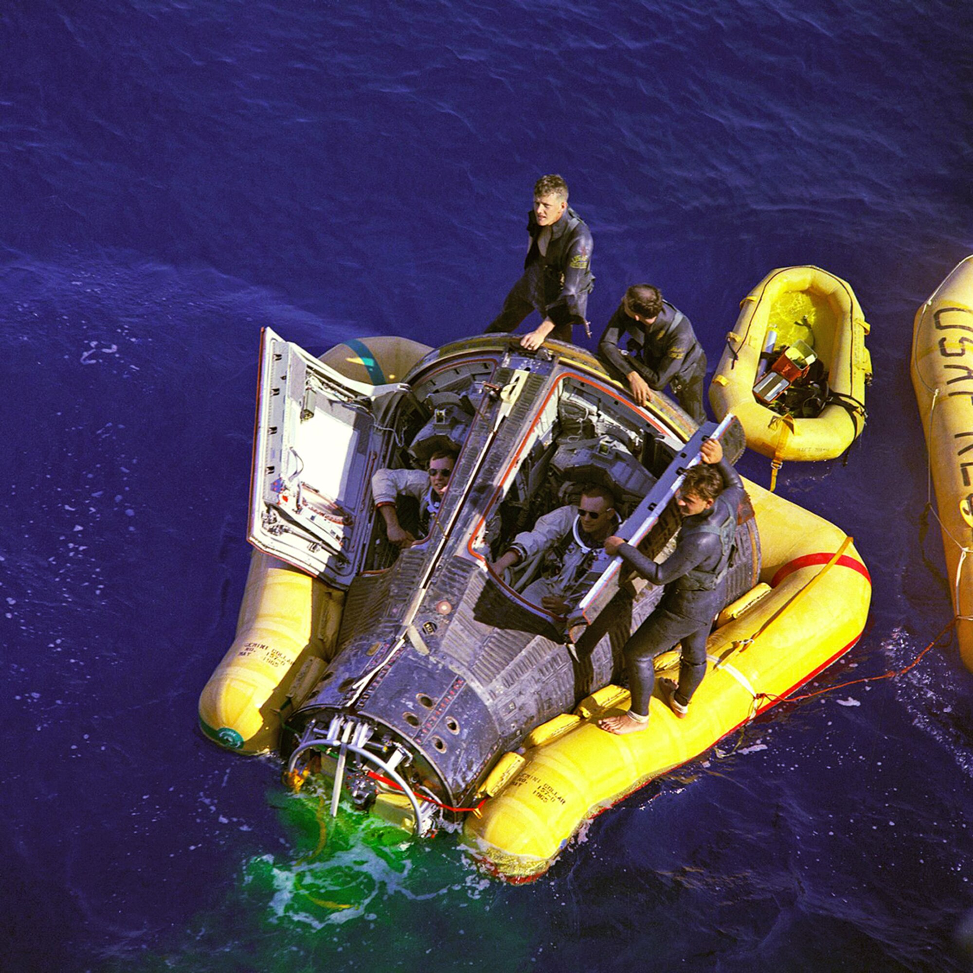 PHILIPPINE SEA, North Pacific Ocean -- Air Force pararescuemen flank Astronauts Neil A. Armstrong and David R. Scott, sitting in the Gemini 8 space craft, while awaiting the arrival of the recovery ship, the USS Leonard F. Mason after splashdown in the Pacific Ocean Mar. 16, 1966. Reservists from the 920th Rescue Wing at Patrick Air Force Base, Fla. provide first-response contingency medical and rescue support for all NASA shuttle launches. With the advent of the NASA's new capsule-based, manned-spaceflight program, Constellation, Air Force pararescuemen will once again greet astronauts on the high seas following splashdown. (NASA courtesy photo)