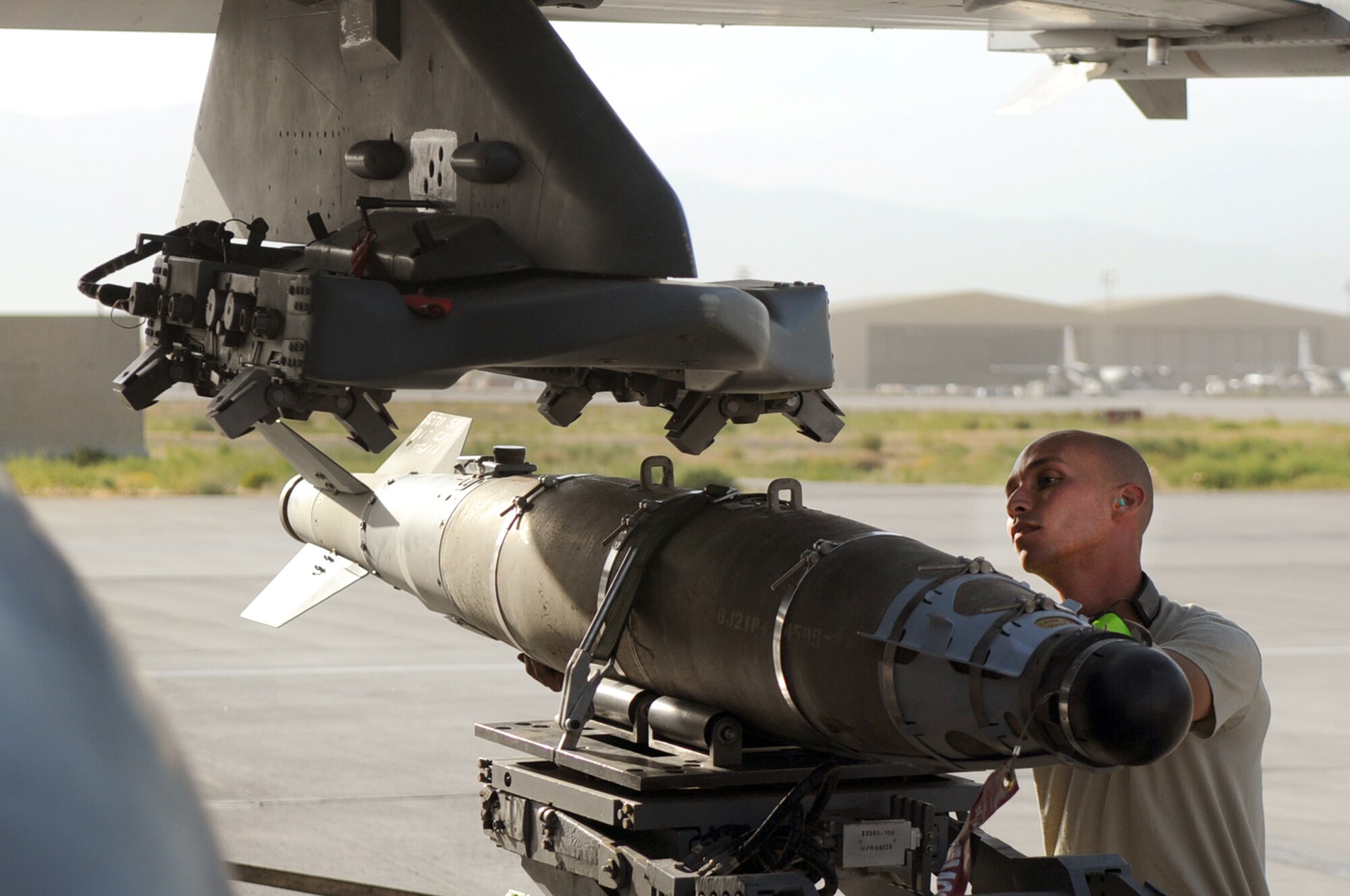 BAGRAM AIRFIELD, Afghanistan -- Staff Sgt. Juan Rodriguez Lopez, 455th Expeditionary Aircraft Maintenance Squadron weapons load crew chief, loads a GBU-54 bomb onto an F-16 Fighting Falcon here July 7. Sergeant Lopez is responsible for inspecting and loading munitions. The inspection process consists of examining munitions for defects, imperfections and ensuring they match mission requirements. After the bombs have been loaded they go through a minimum of five additional inspections before the F-16 takes off. Sergeant Rodriguez Lopez is stationed at Aviano Air Base, Italy. (U.S. Air Force photo by Senior Airman Krista Rose) 
